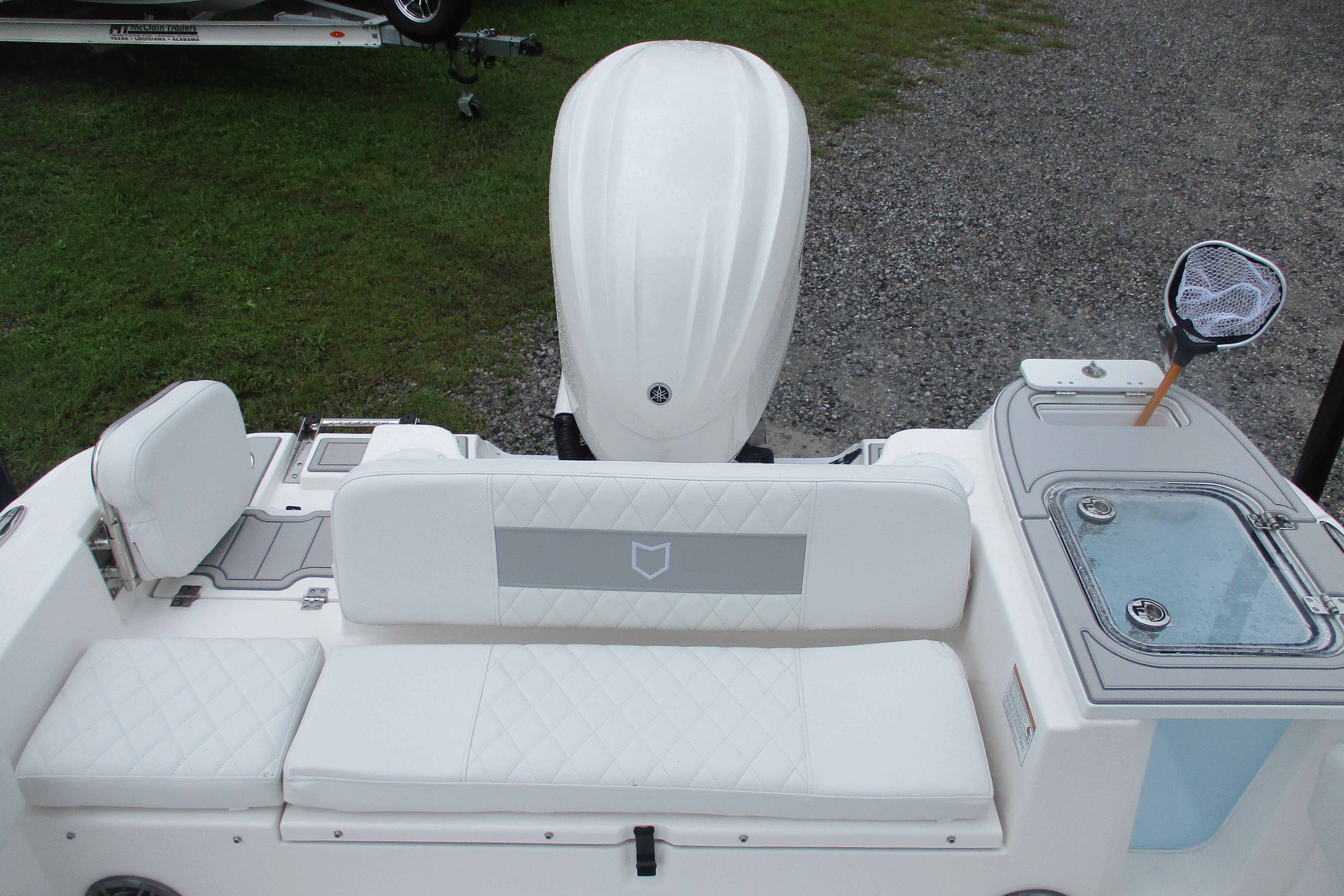 2026 Sea Fox 248 Commander boat interior with white seating and outboard motor.
