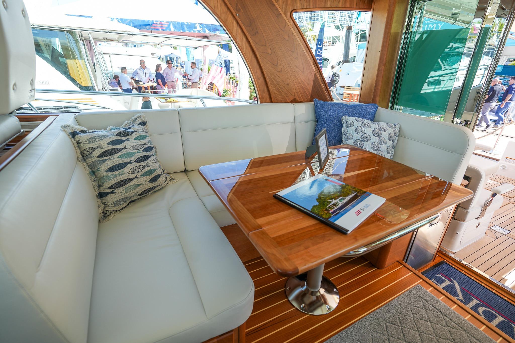 Luxurious interior of 2026 Sabre 51 Salon Express yacht with elegant seating and wooden table.