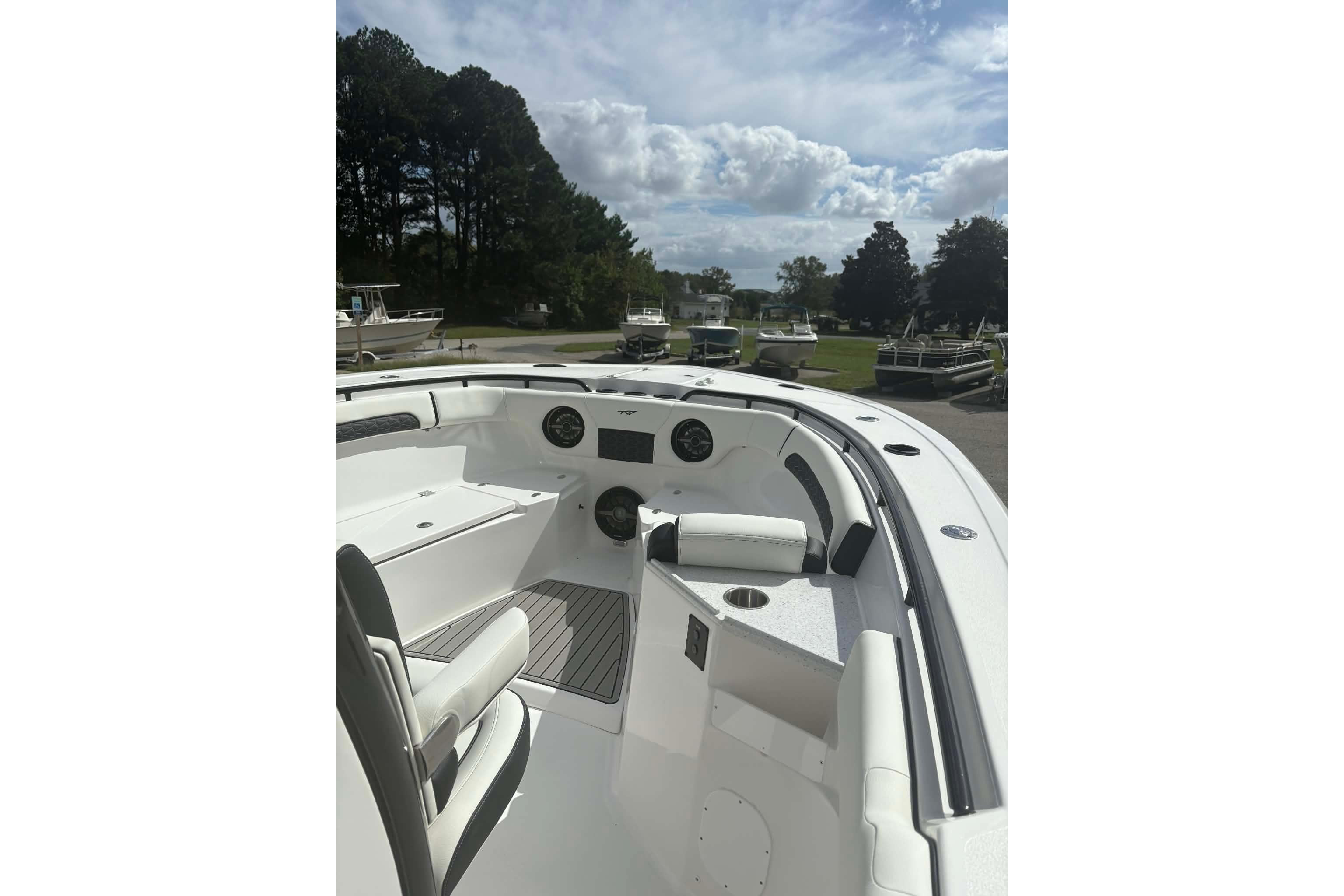 2026 Tidewater 282 CC Adventure boat interior with seating and dashboard, under a partly cloudy sky.