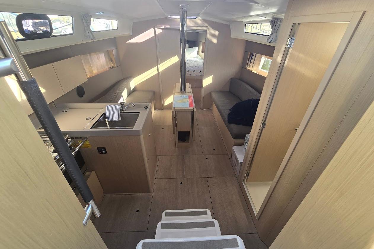 Interior of 2023 Beneteau Oceanis 38.1 yacht, featuring modern kitchen and cozy seating area.