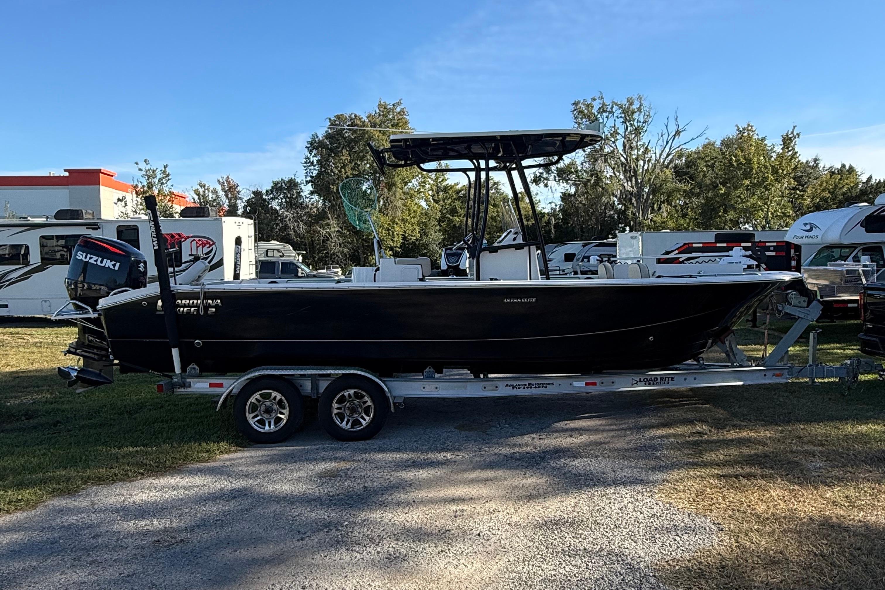 2021 Carolina Skiff 26 Ultra Elite boat on trailer, parked outdoors.