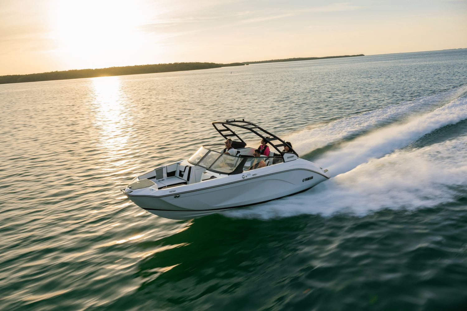 Yamaha 222SD boat speeding across calm water at sunset.