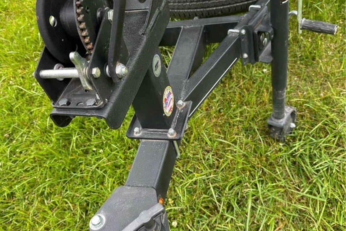 Trailer hitch of a 2022 Bass Tracker 195TXW on grass.