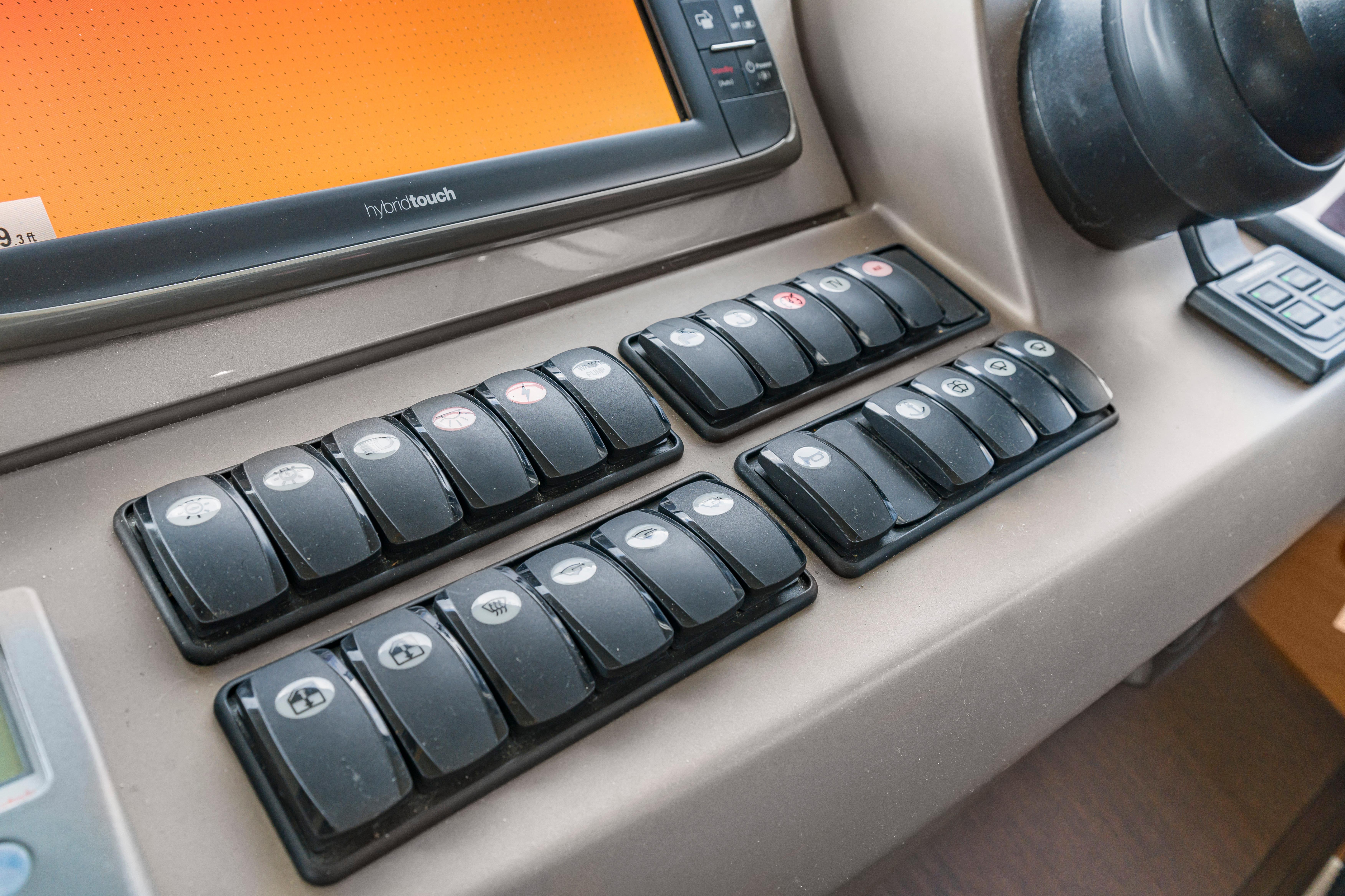 Control panel of a 2017 Prestige 500 yacht with multiple switches and touchscreen display.