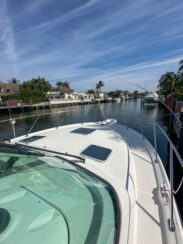 Tiara Yachts 3200 Open 2006 on a serene canal with palm trees and blue sky.