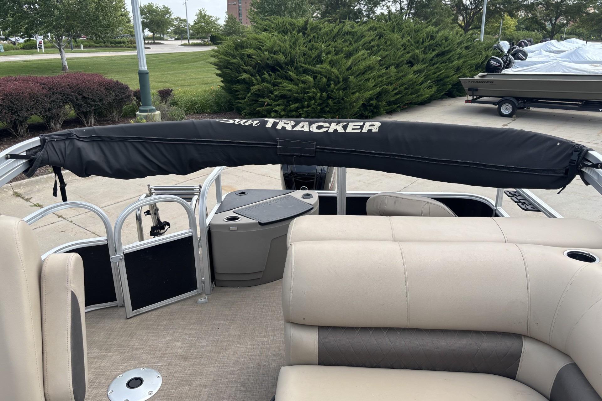 2023 Sun Tracker SportFish 20 DLX pontoon boat interior with beige seating and covered canopy.