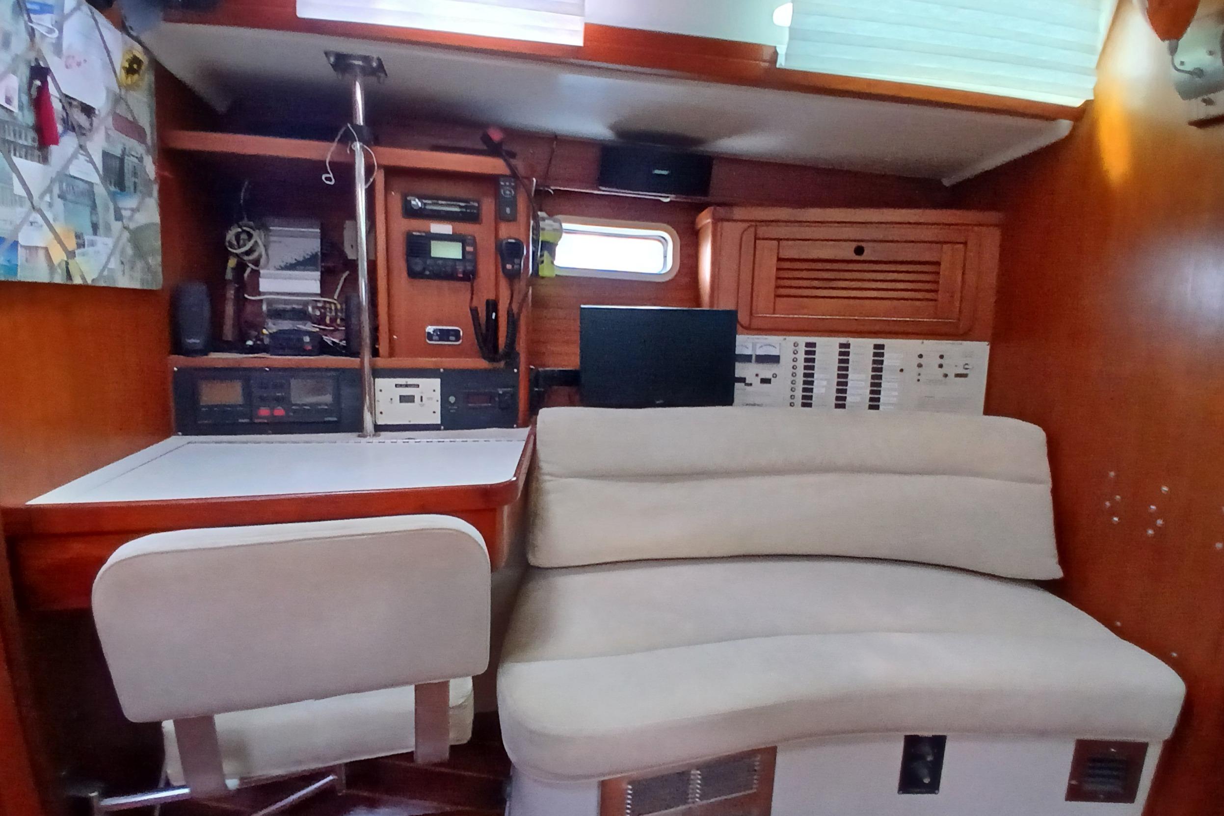 Navigation station inside a 1995 Catalina 42 MkII sailboat, featuring control panels and seating.