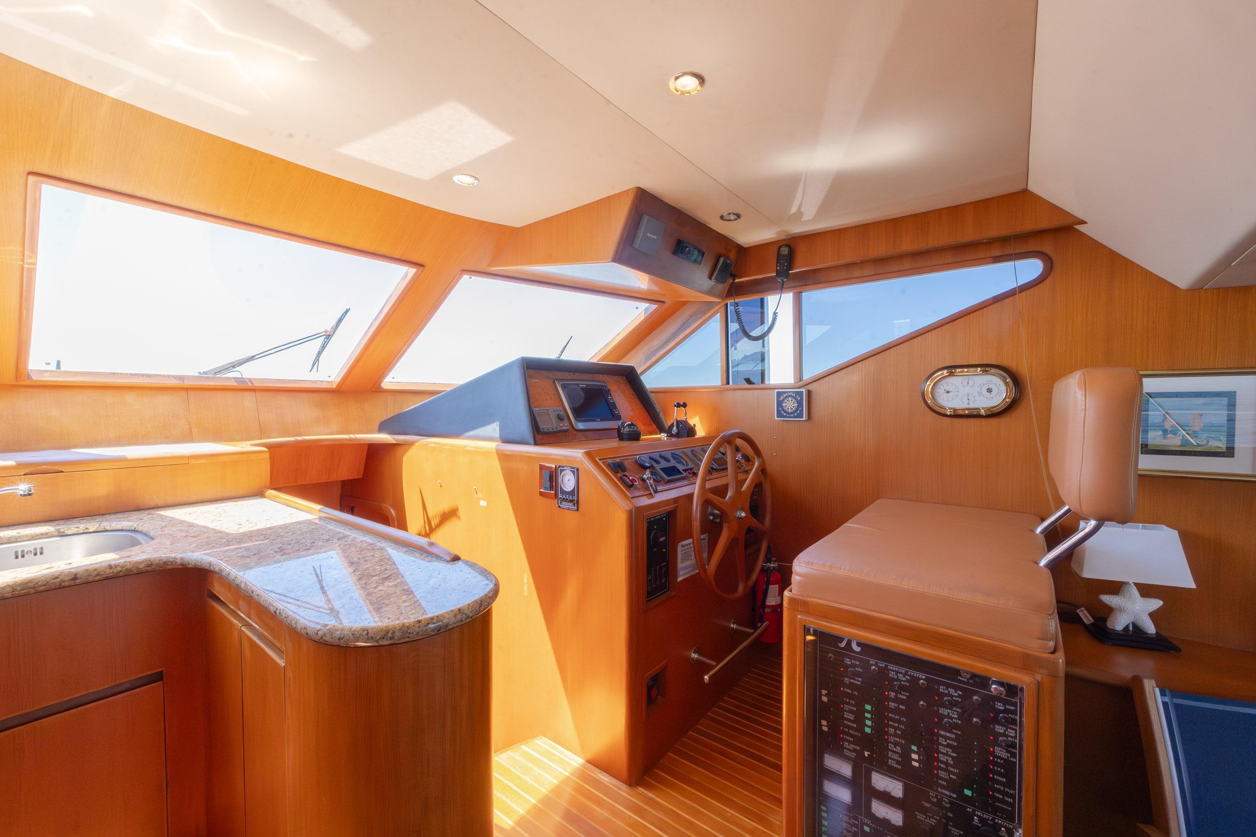 Luxurious helm of 2005 Ocean Alexander 52 Sedan yacht with wooden interior and modern controls.