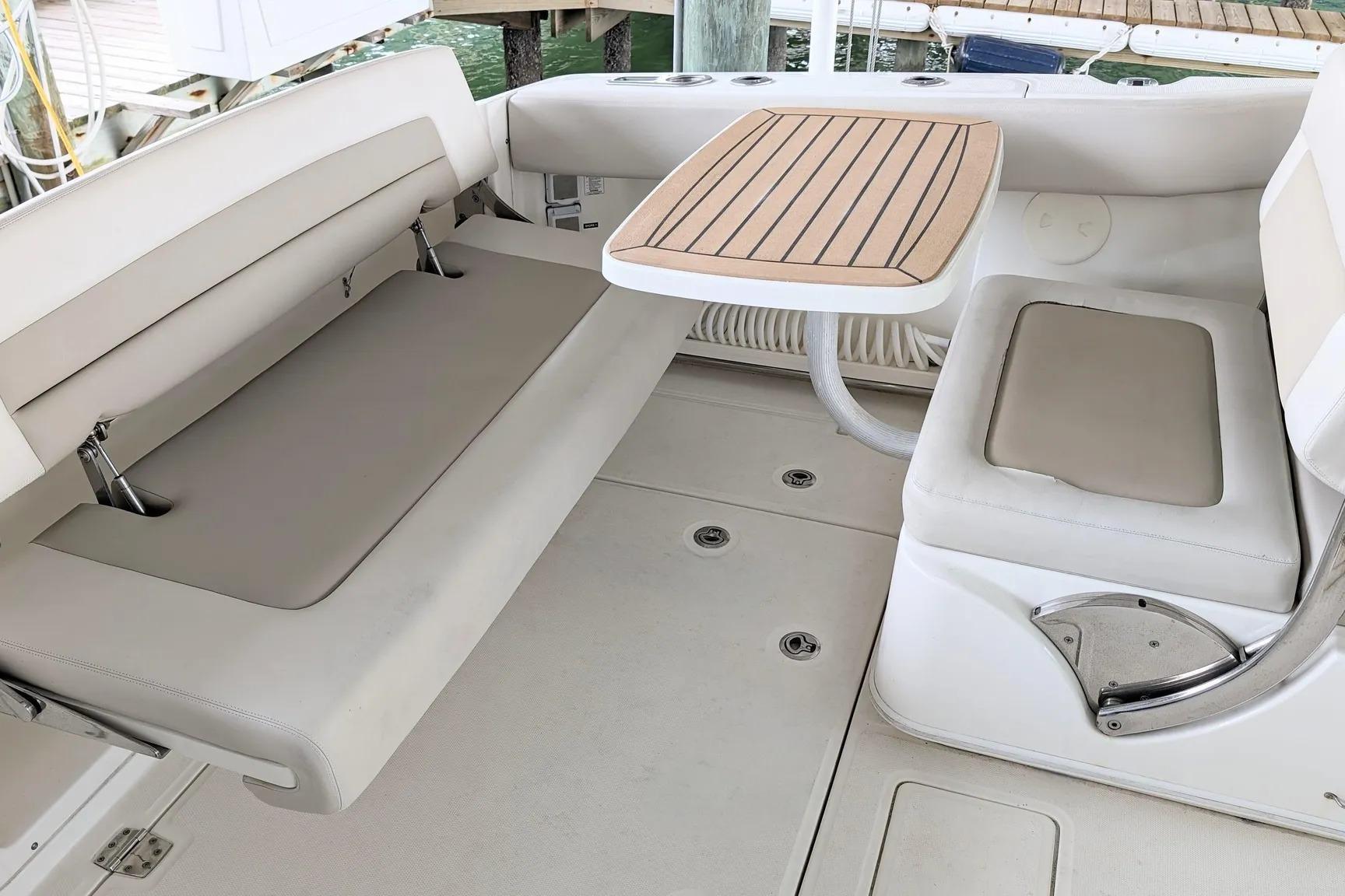 Interior seating area of a 2017 Boston Whaler 320 Vantage boat with table.