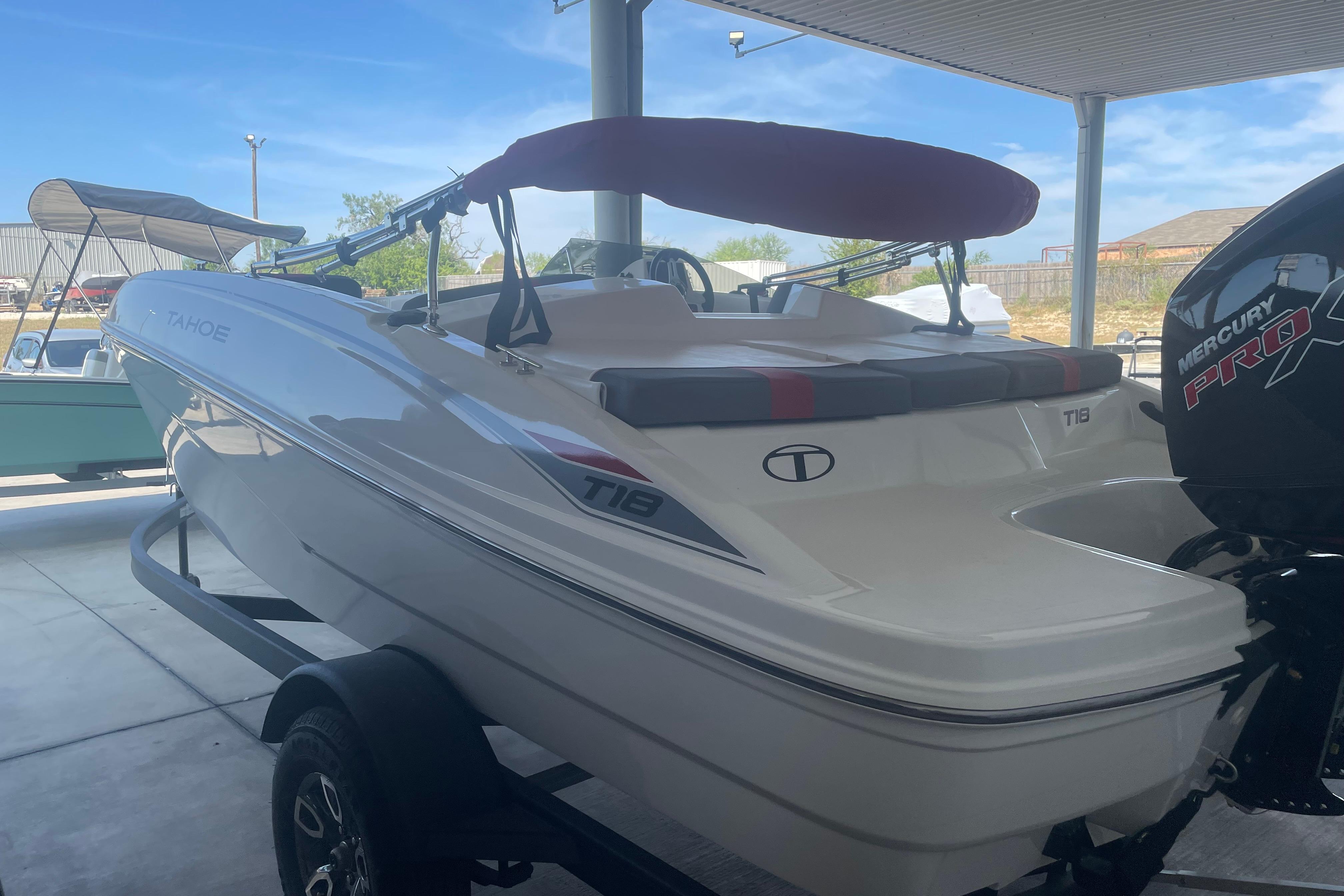 2026 Tahoe T18 boat with Mercury Pro engine, parked under a canopy.