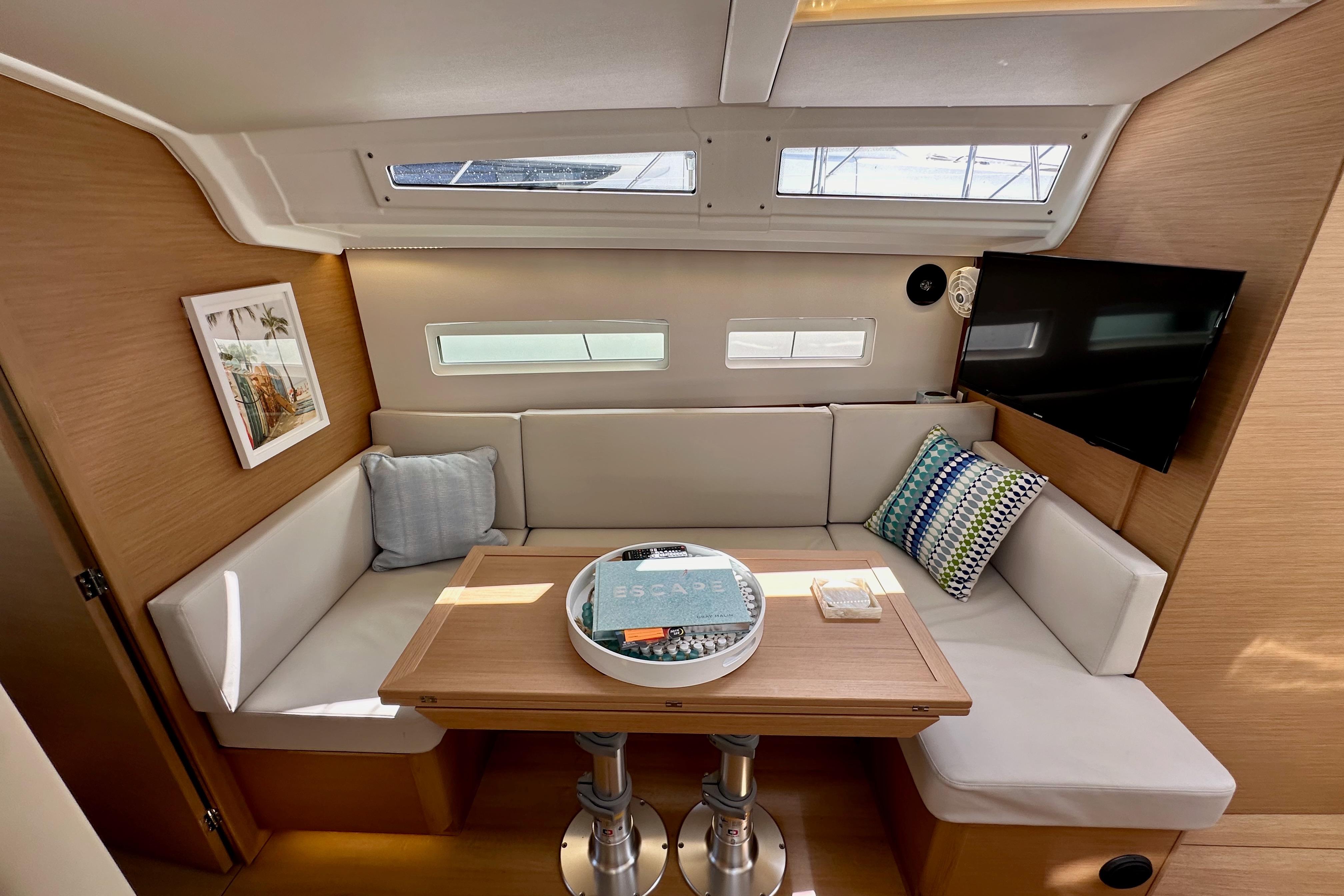 2024 Jeanneau Sun Odyssey 410 interior with cozy seating, table, and modern decor.