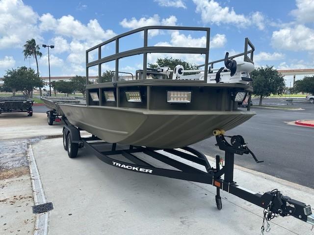 2025 Tracker Grizzly 2072 CC Sportsman Kicker boat on trailer, parked outdoors.