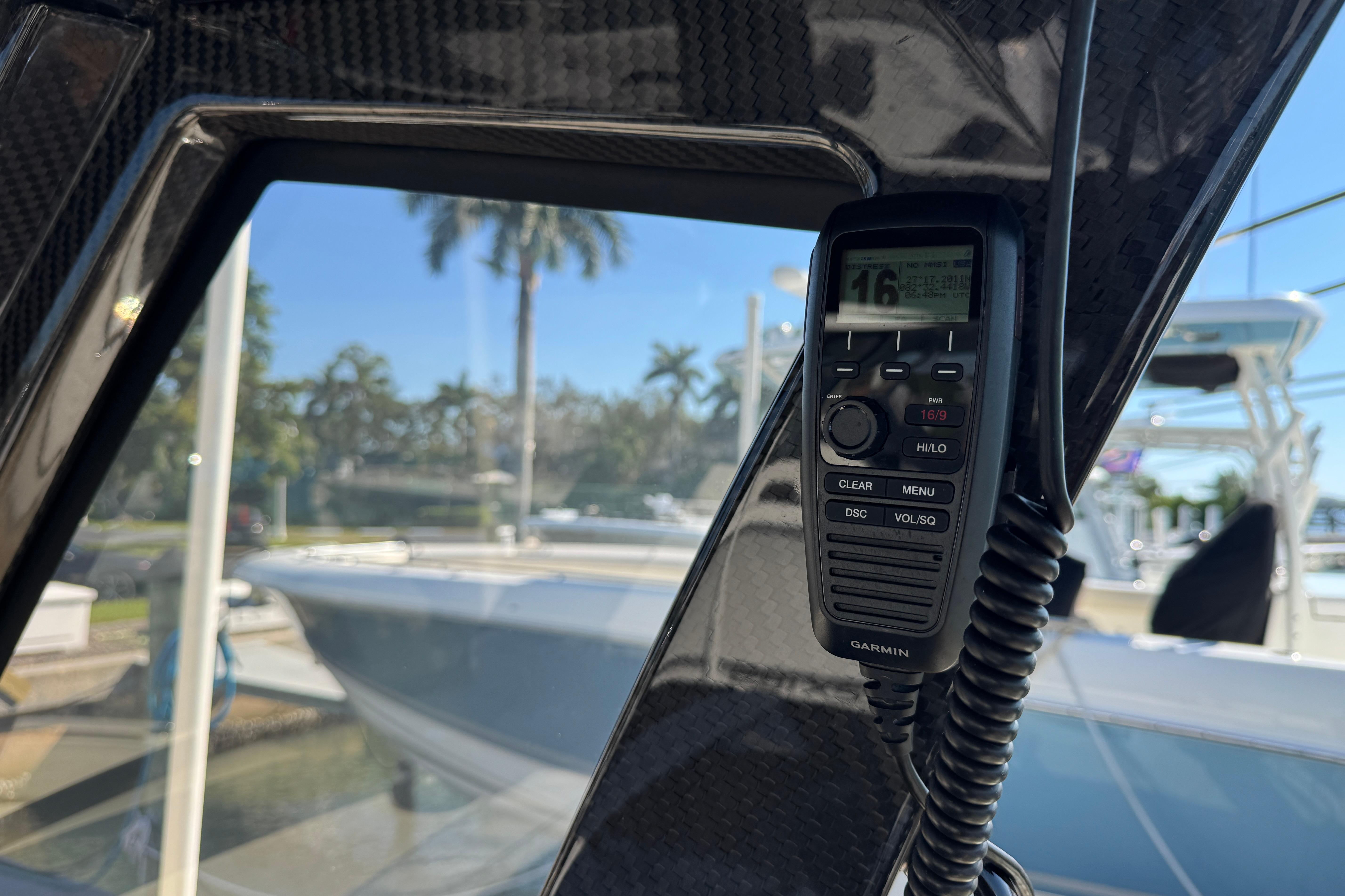 2025 Scout 281 XSS boat interior with Garmin radio, docked near palm trees.