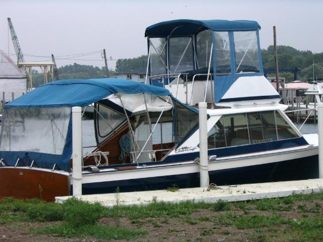 1967 Chris-Craft Sea Skiff 32 Sport Cruiser docked with blue canopy.