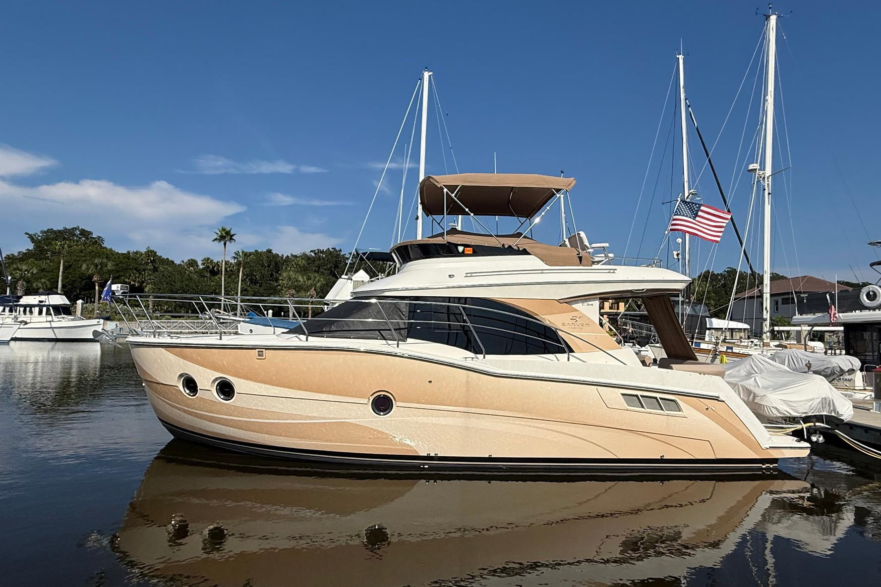 2013 Carver C34 yacht docked in a marina, featuring sleek design and American flag.