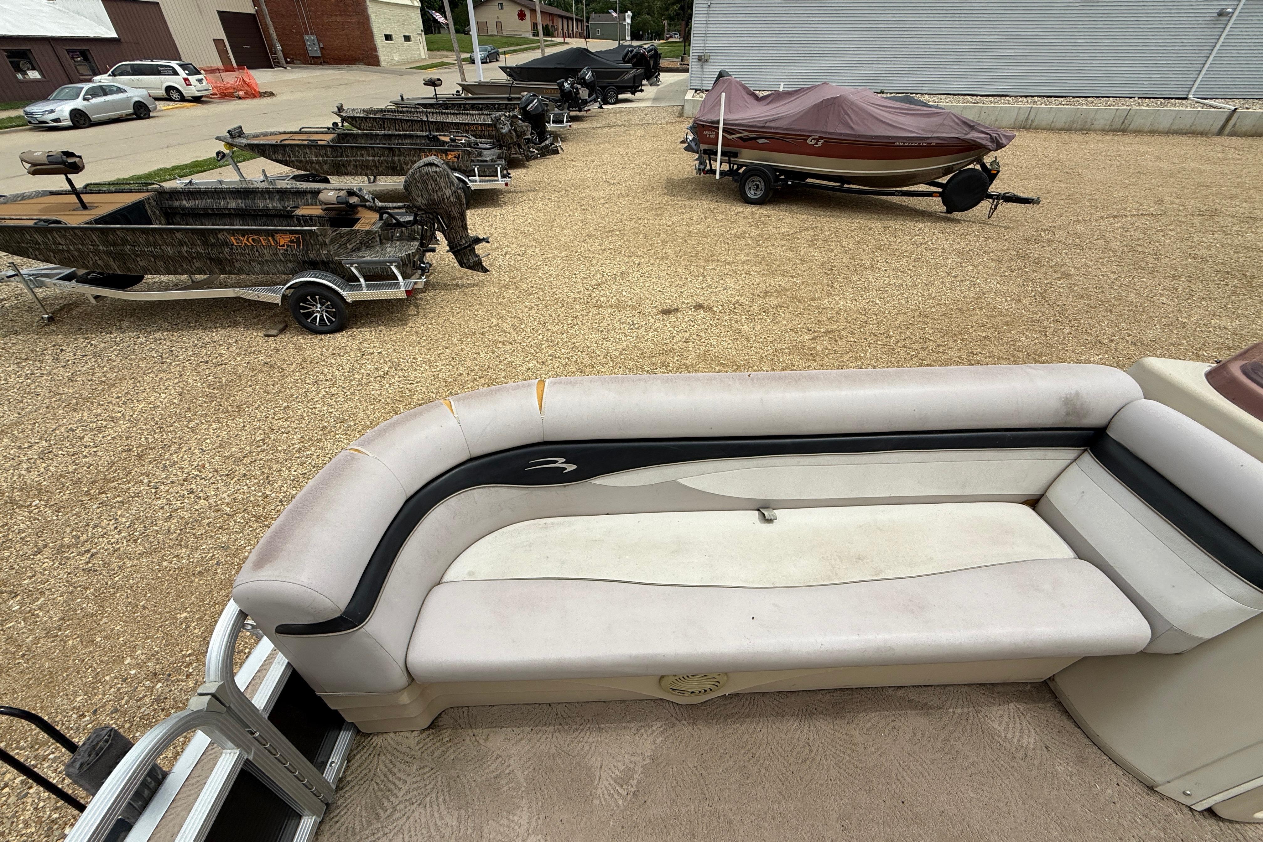 2010 Bennington 20SLi pontoon boat interior with nearby parked boats on gravel lot.