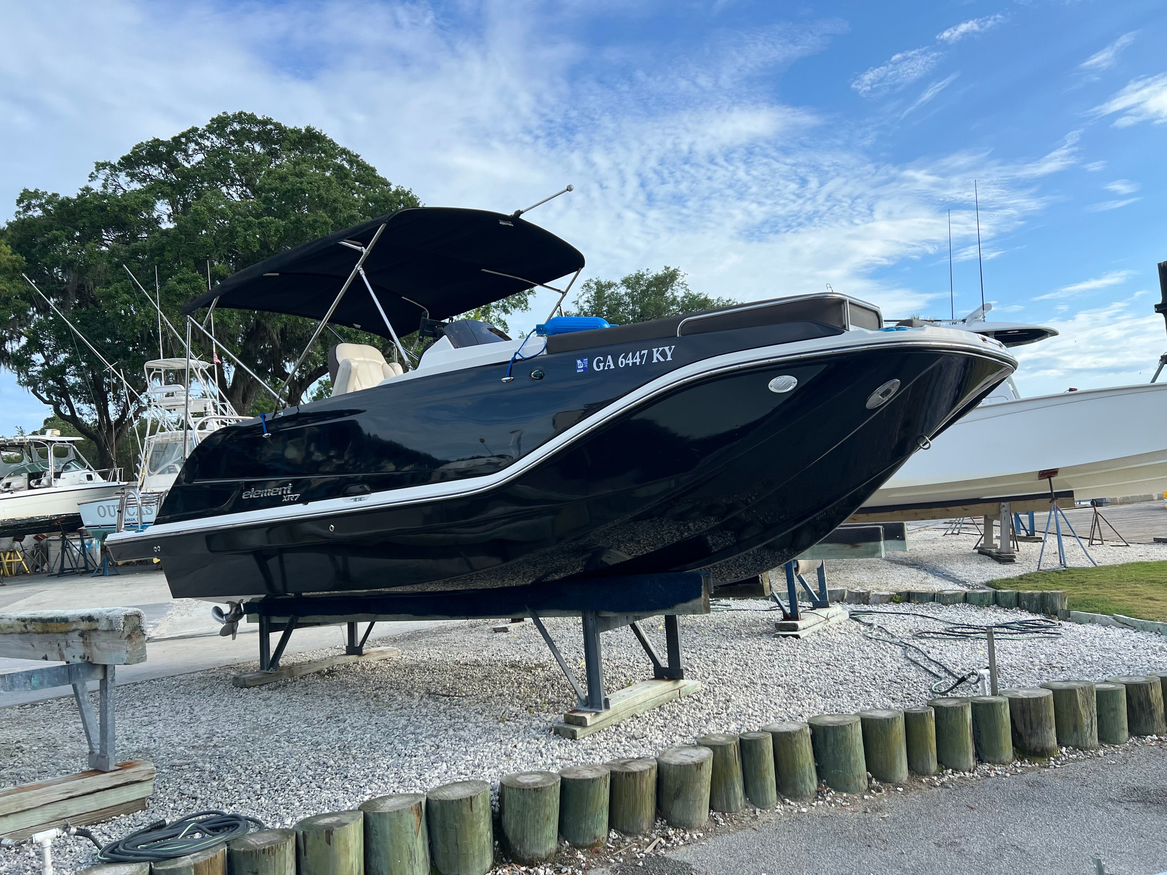 A 2019 Bayliner Element XR7 on a stand, surrounded by other boats.