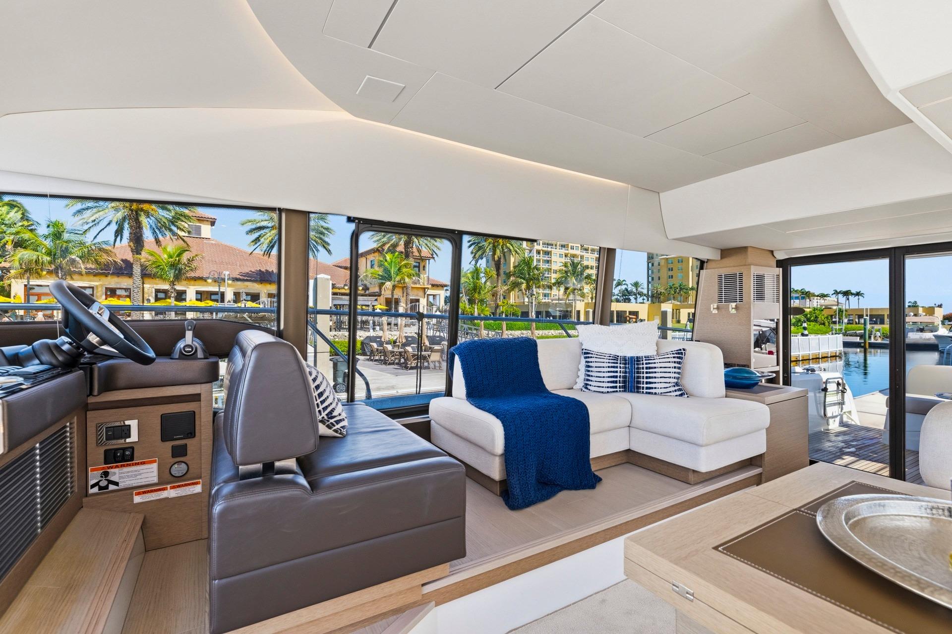 Luxurious interior of 2022 Prestige 520 yacht with modern seating and scenic marina view.