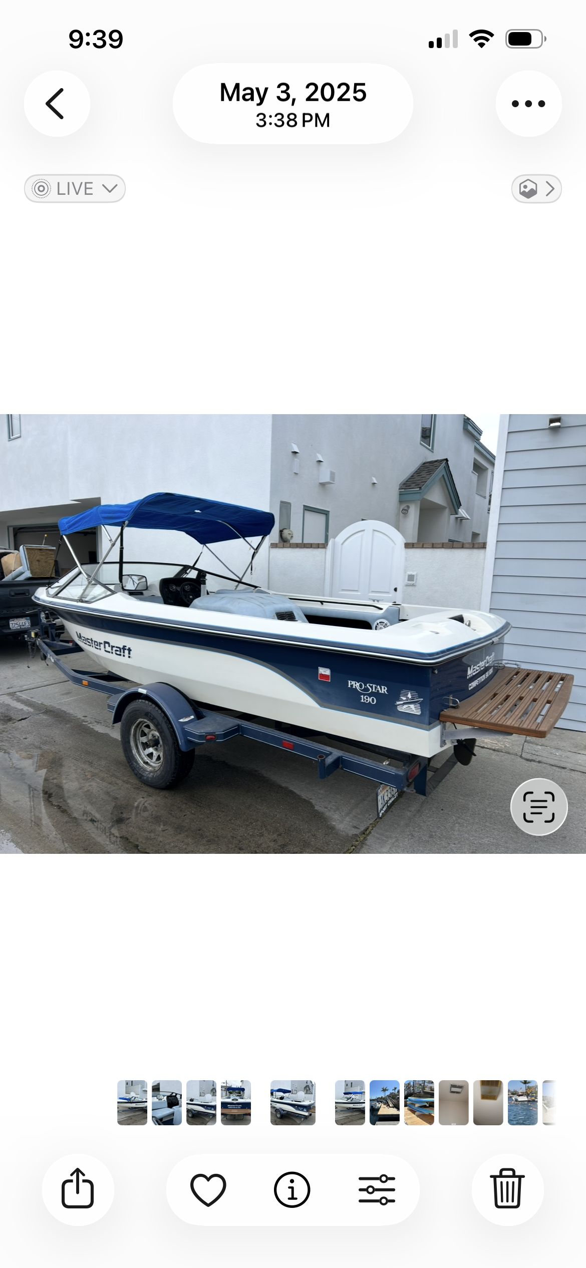 1987 MasterCraft ProStar 190 with blue canopy, parked on a trailer.