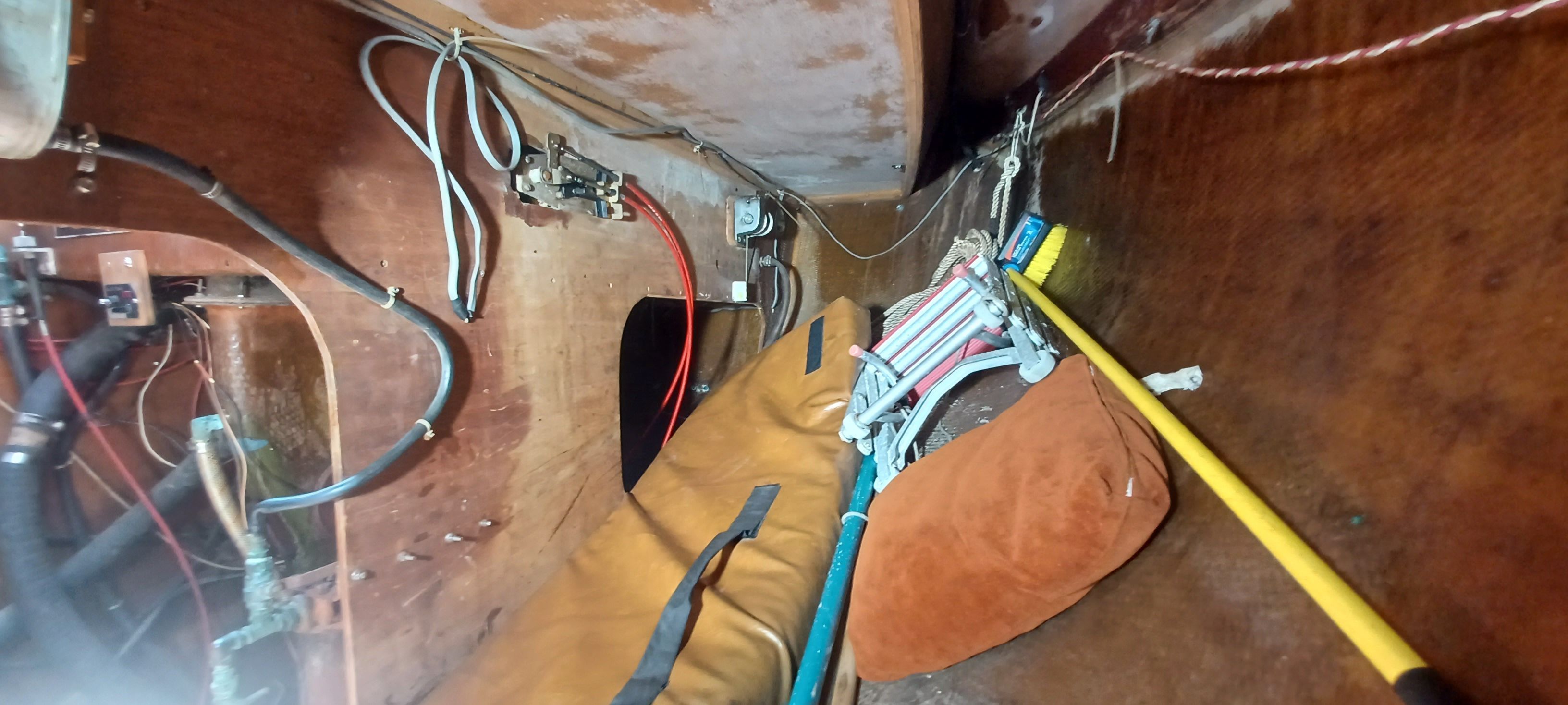 Interior of a boat with wooden paneling and various tools.