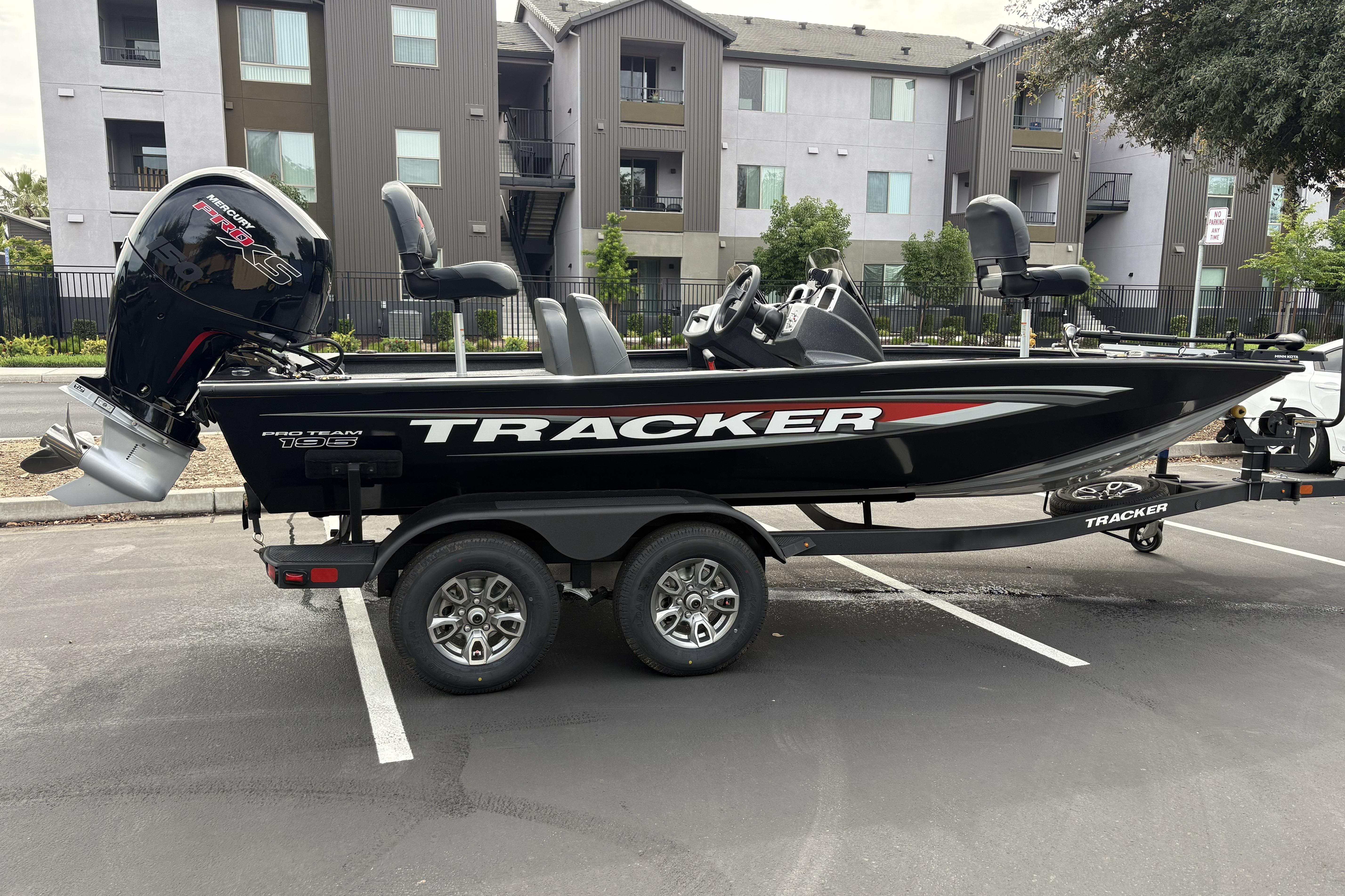 2026 Tracker Pro Team 195 boat on trailer in parking lot.