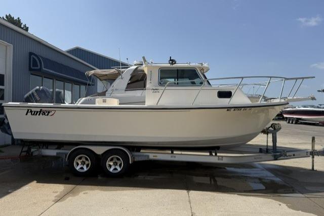 2006 Parker 2520 SL Sport Cabin boat on trailer, parked outside a building.
