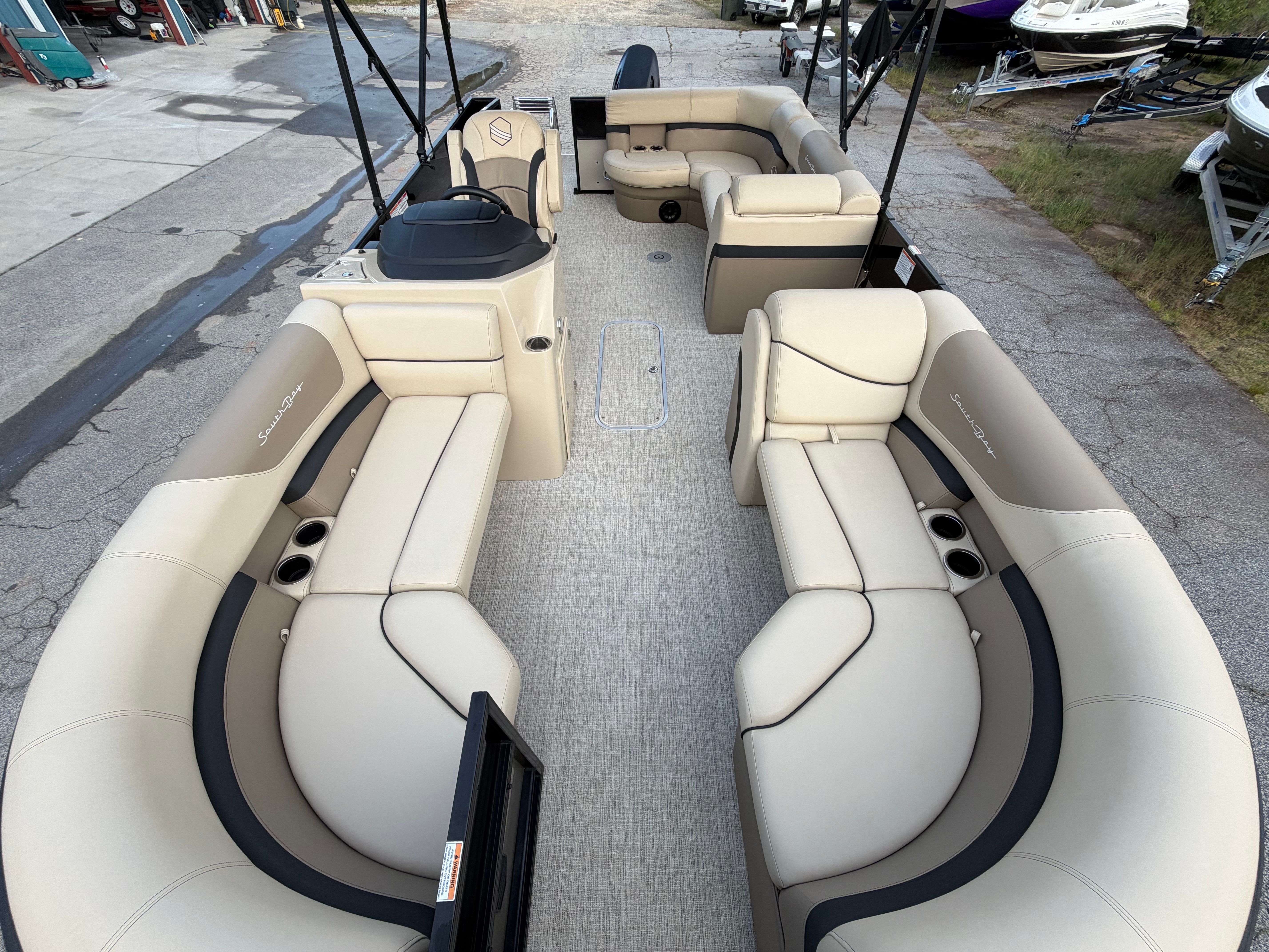Interior of 2023 South Bay S222 CR2 pontoon boat with beige seating.