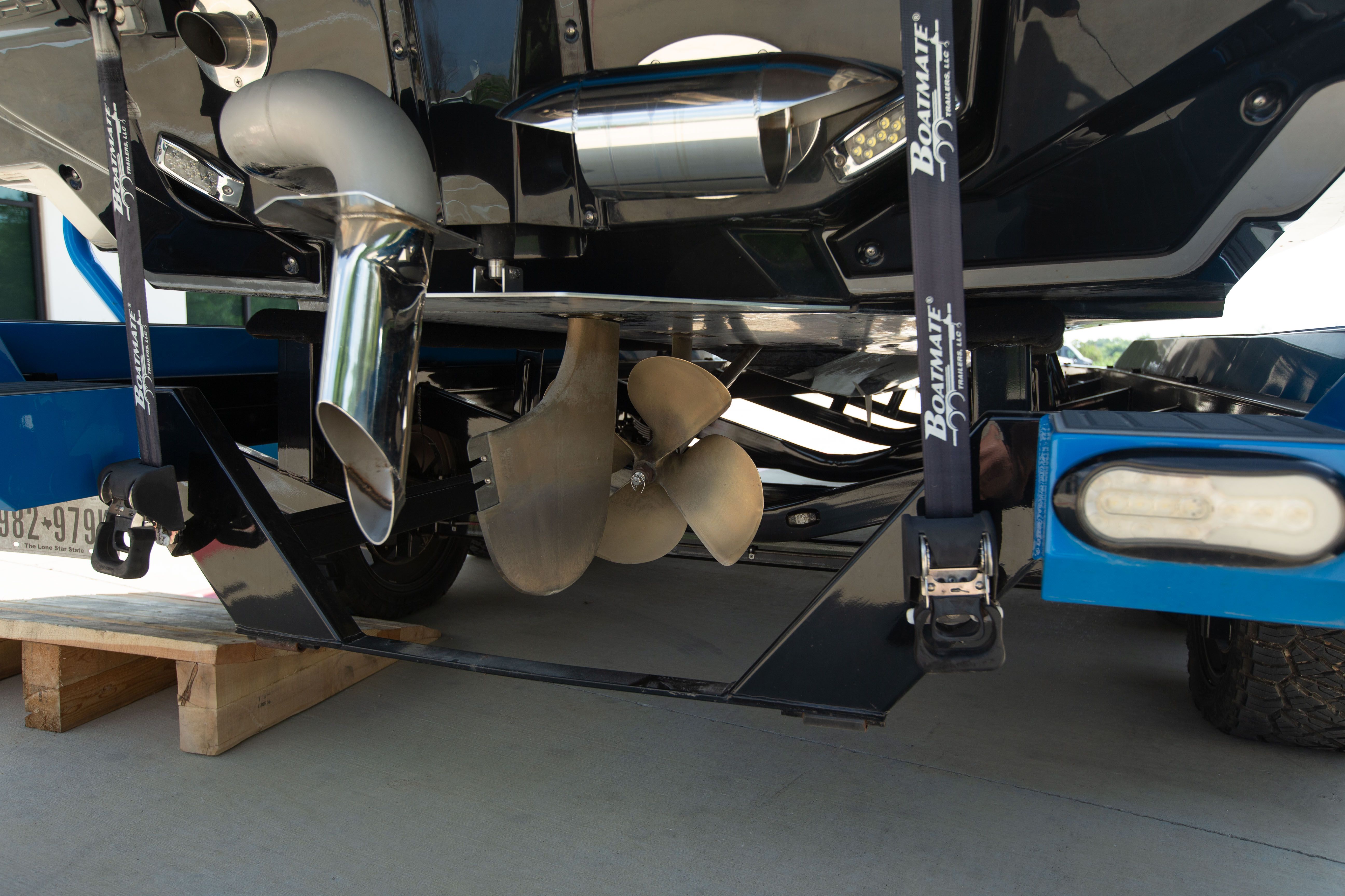 Close-up of the propeller and exhaust of a Nautique boat on a trailer.