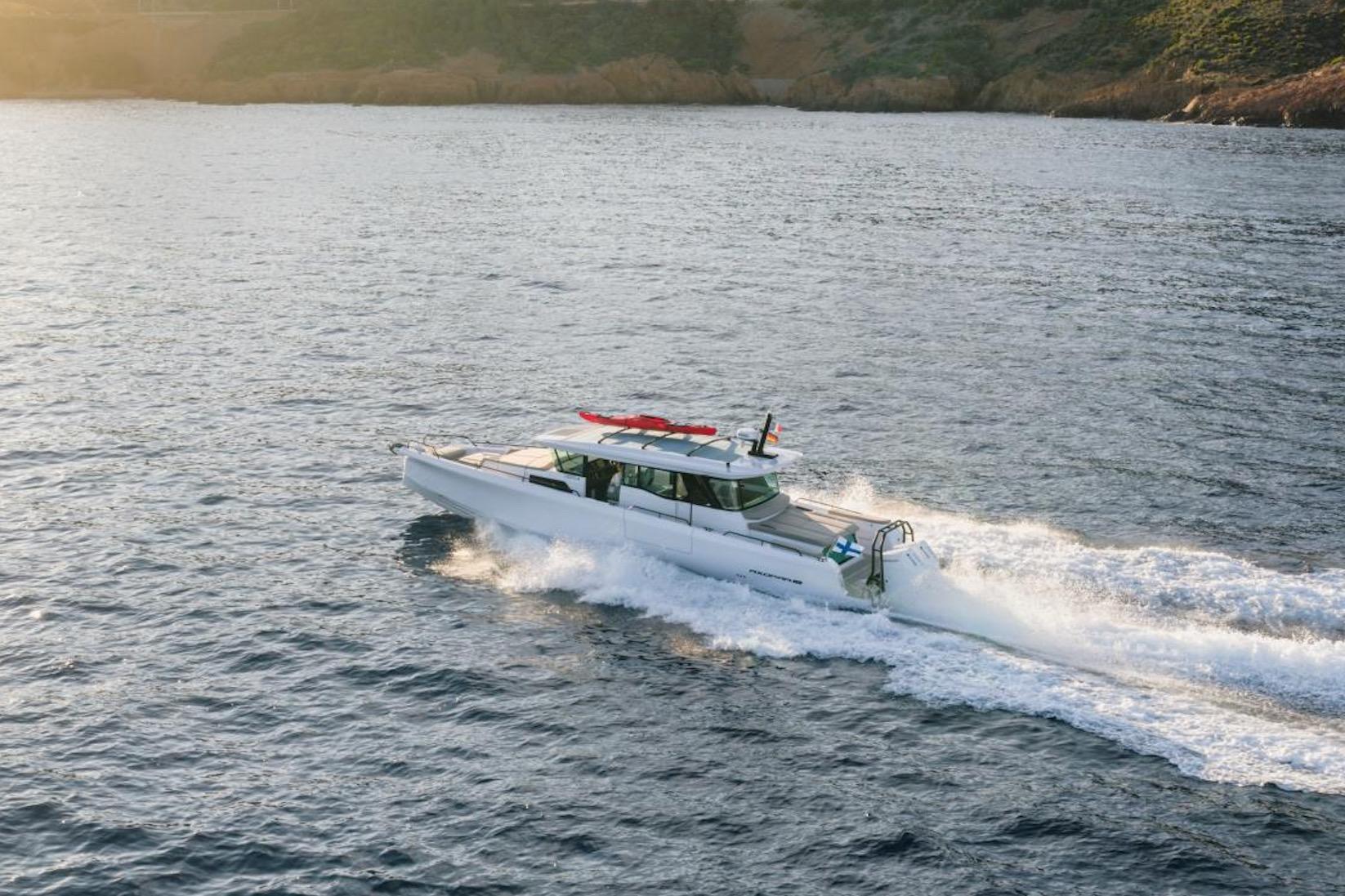 2027 Axopar 45 XC Cross Cabin cruising on open water at sunset.