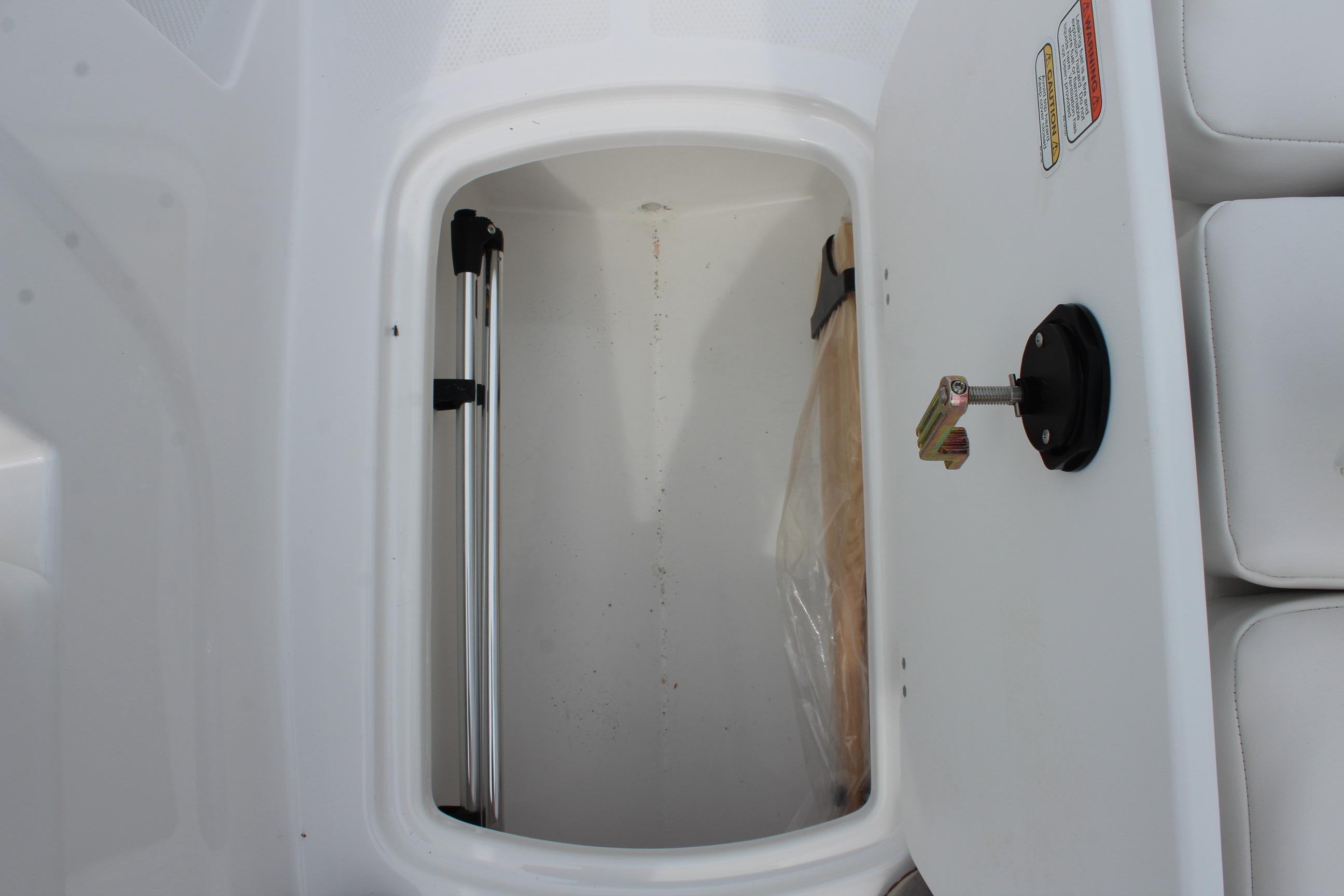 Storage compartment in 2026 Tahoe T16 boat, featuring white interior and metal support.