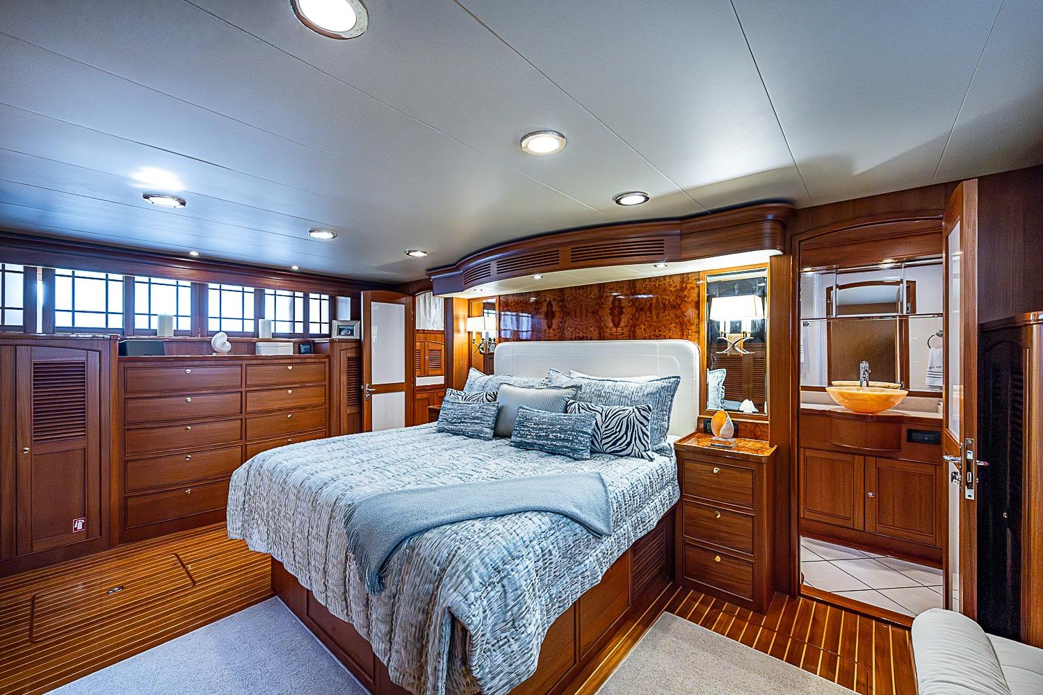 Luxurious bedroom interior of 2014 Marlow 80 Explorer yacht with elegant wood finishes.