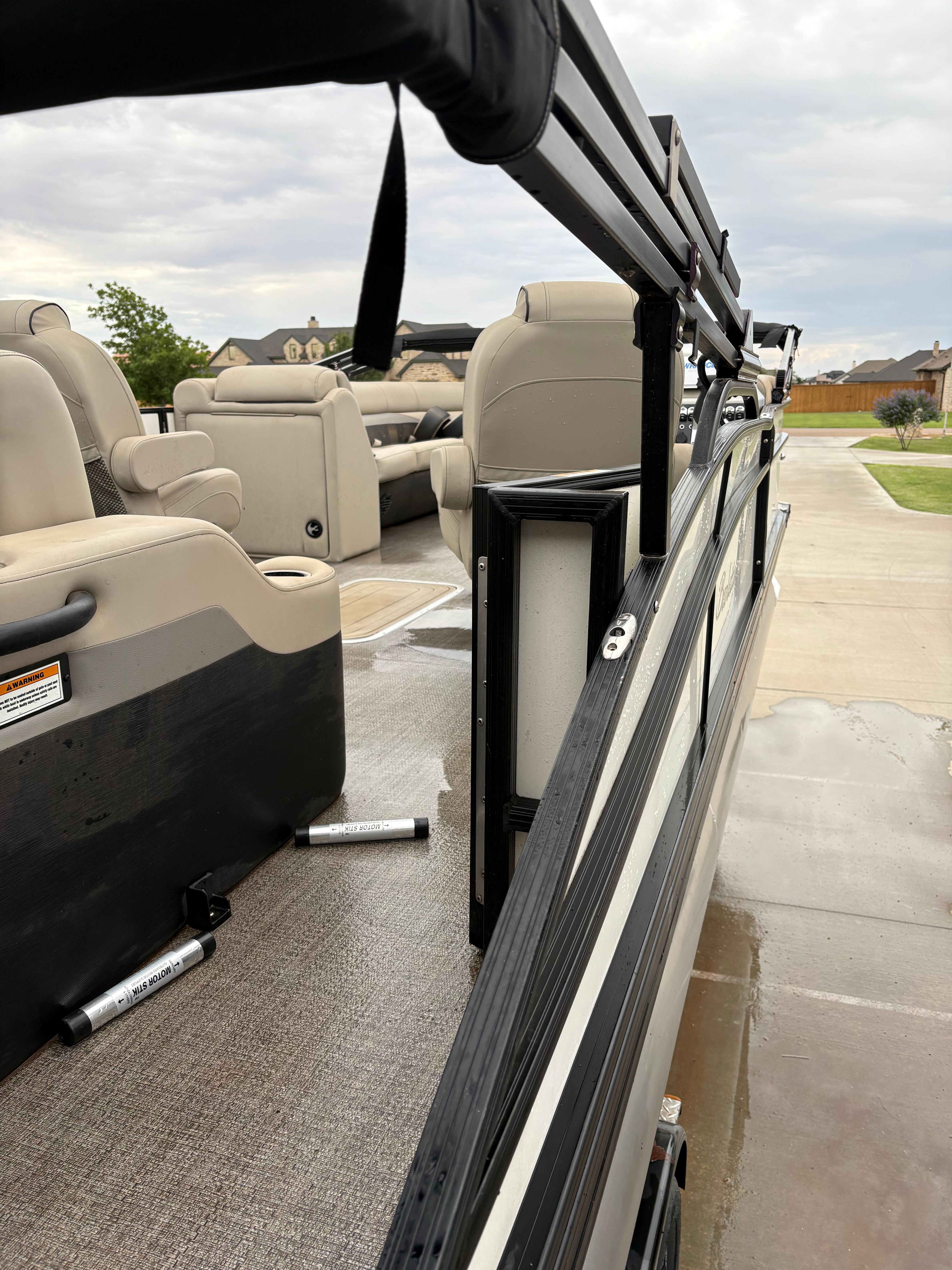 The image shows the interior of a Barletta C24UC pontoon boat with beige seating.