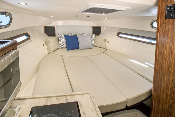 Manufacturer Provided Image: Interior cabin of 2021 Pursuit OS 325 Offshore boat with cozy seating and pillows.