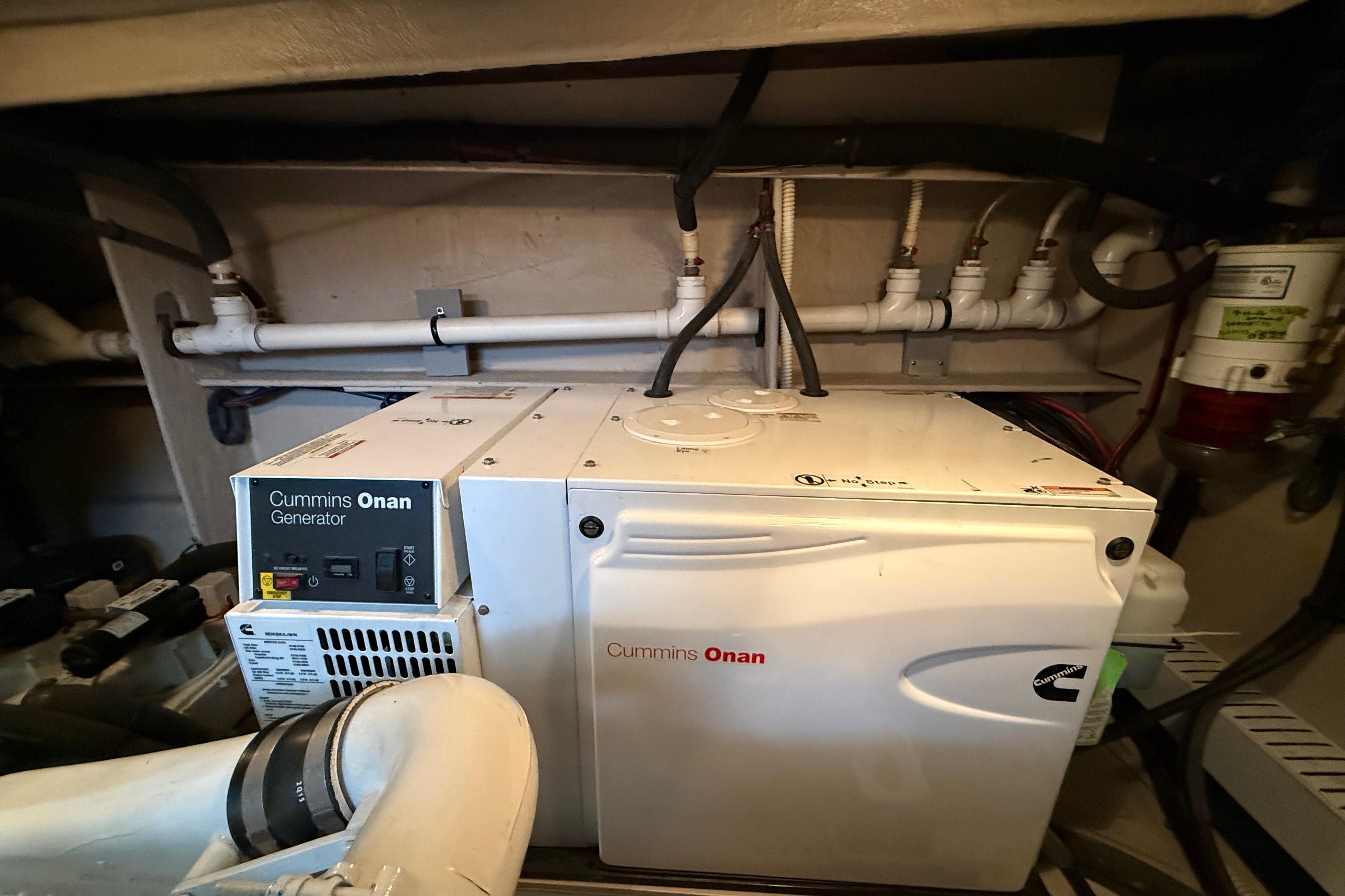 Cummins Onan generator in 2016 Sea Ray Sundancer 510 engine room, surrounded by pipes.