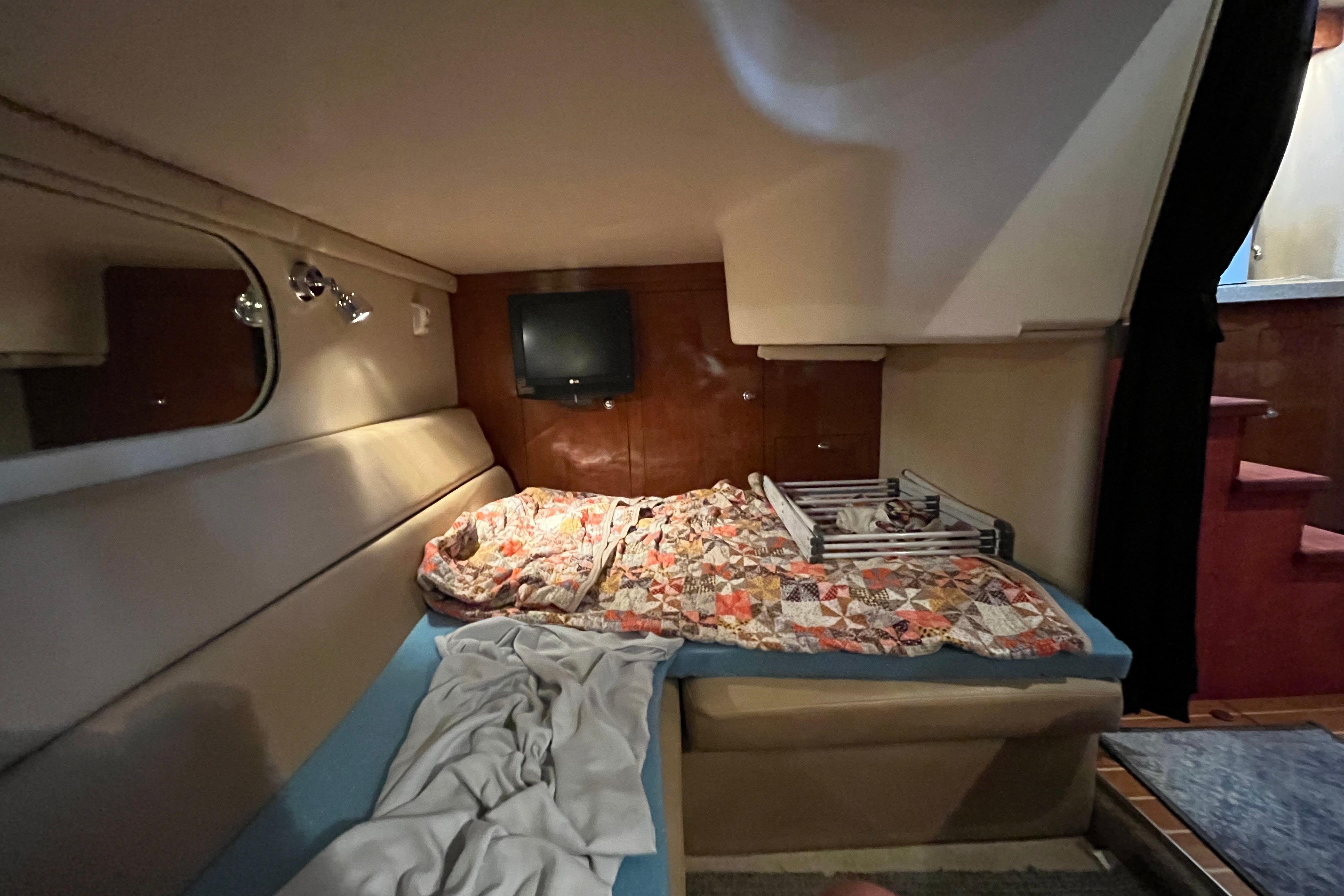 2007 Regal 3760 IB Commodore cabin with bed, TV, and cozy decor.