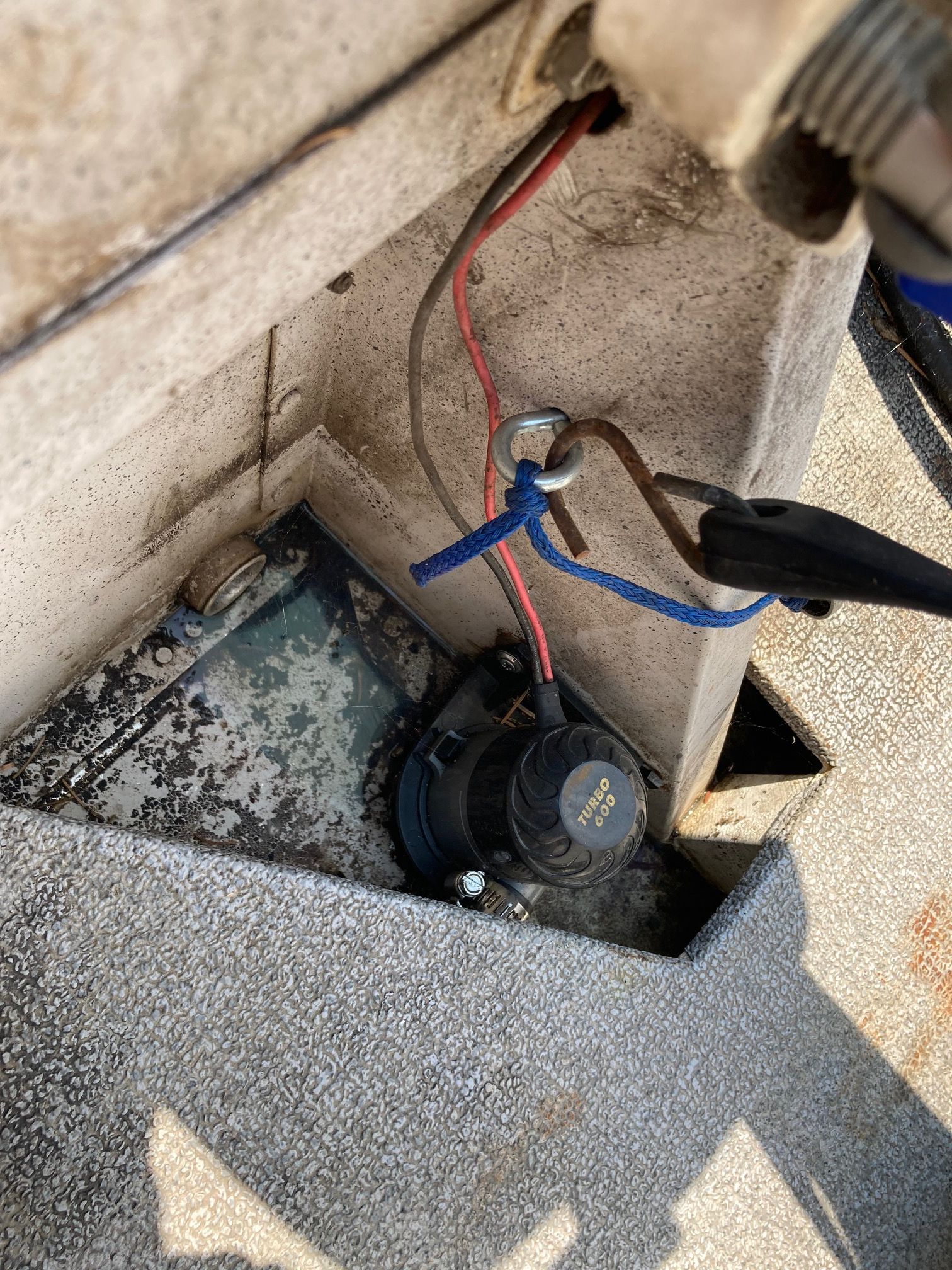 Close-up of a boat interior with wiring and a pump.