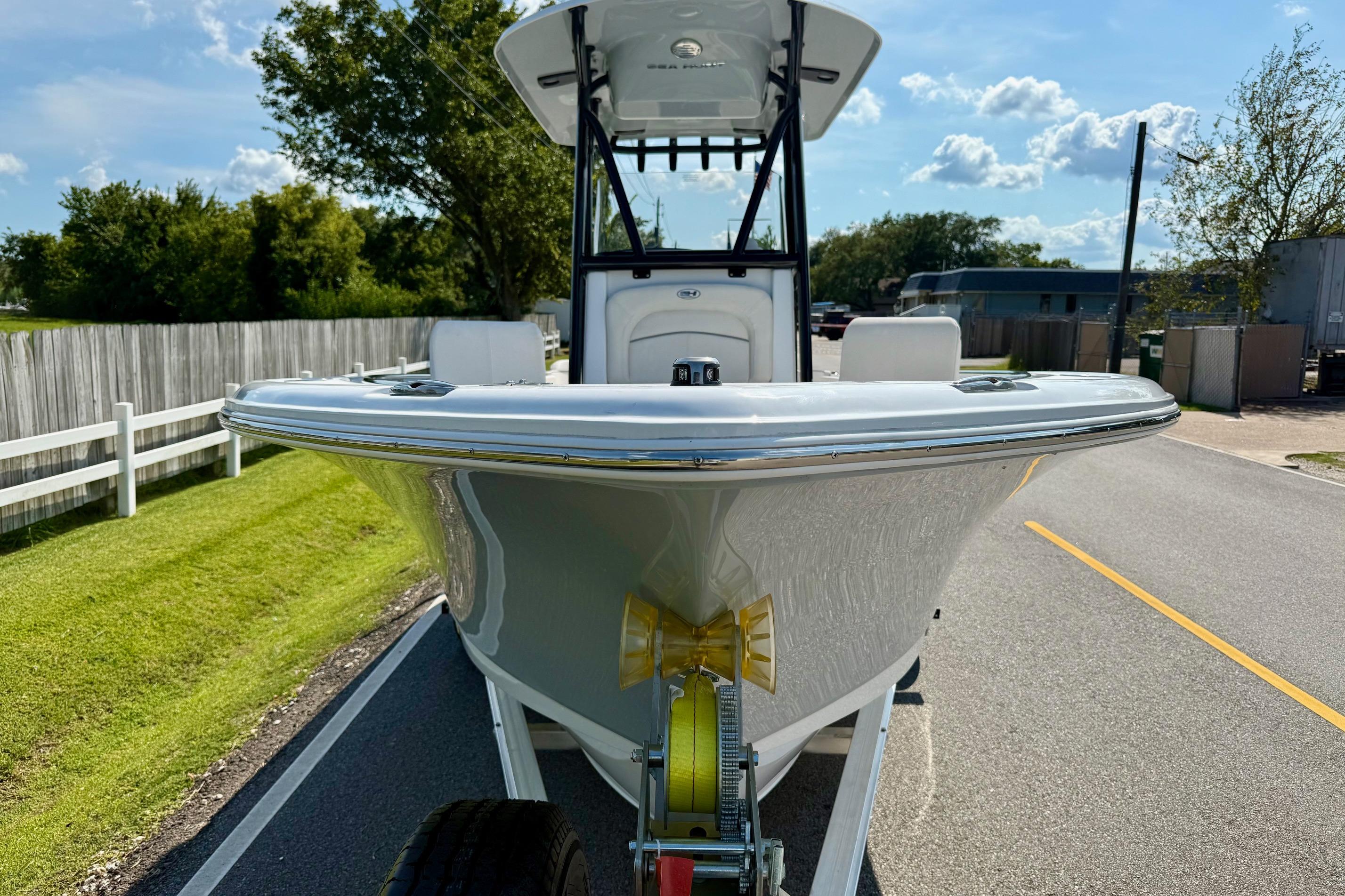 2026 Sea Hunt Ultra 229 boat on trailer, parked on a sunny road.