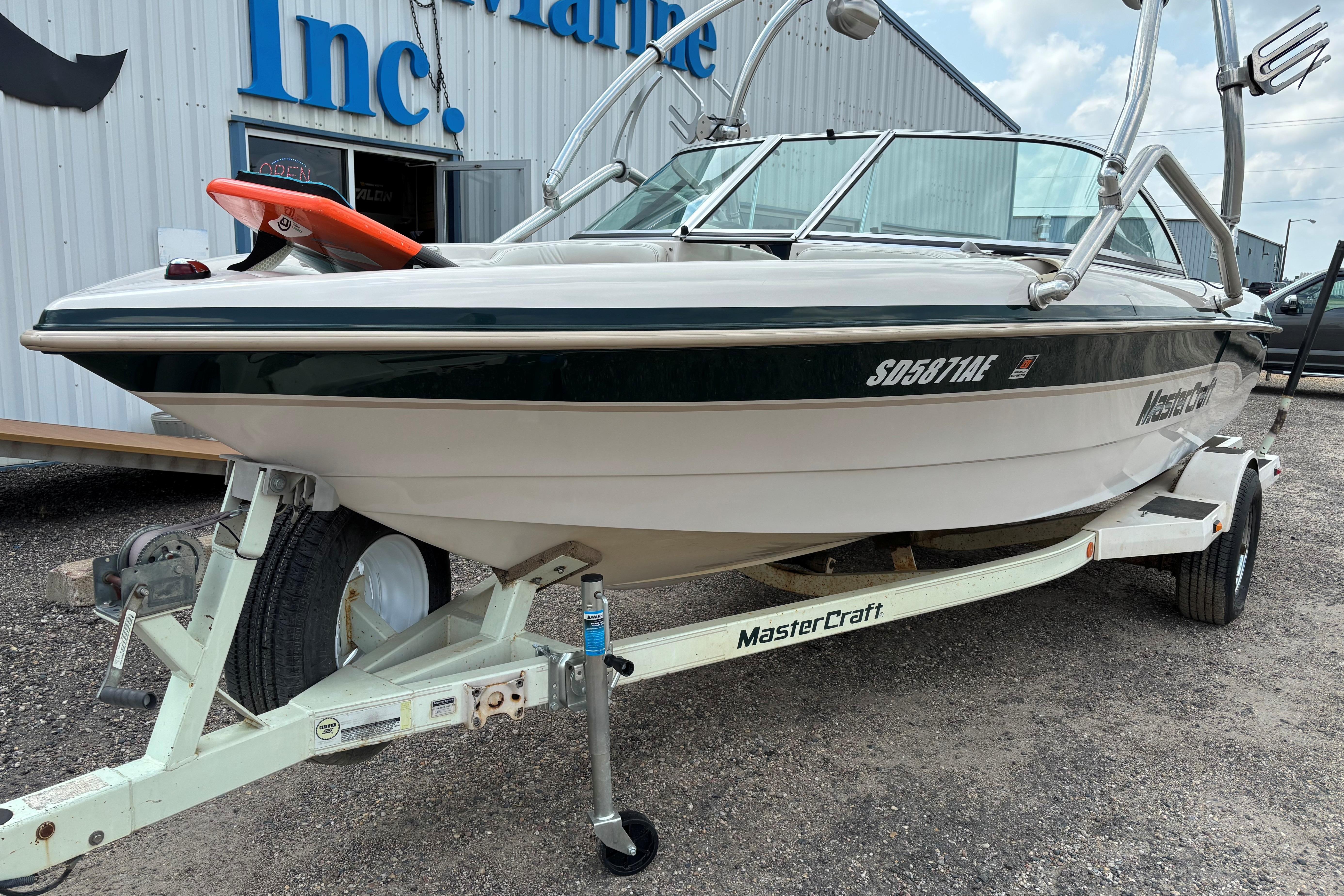 1999 MasterCraft 205 PRO STAR boat on trailer, parked outside a building.
