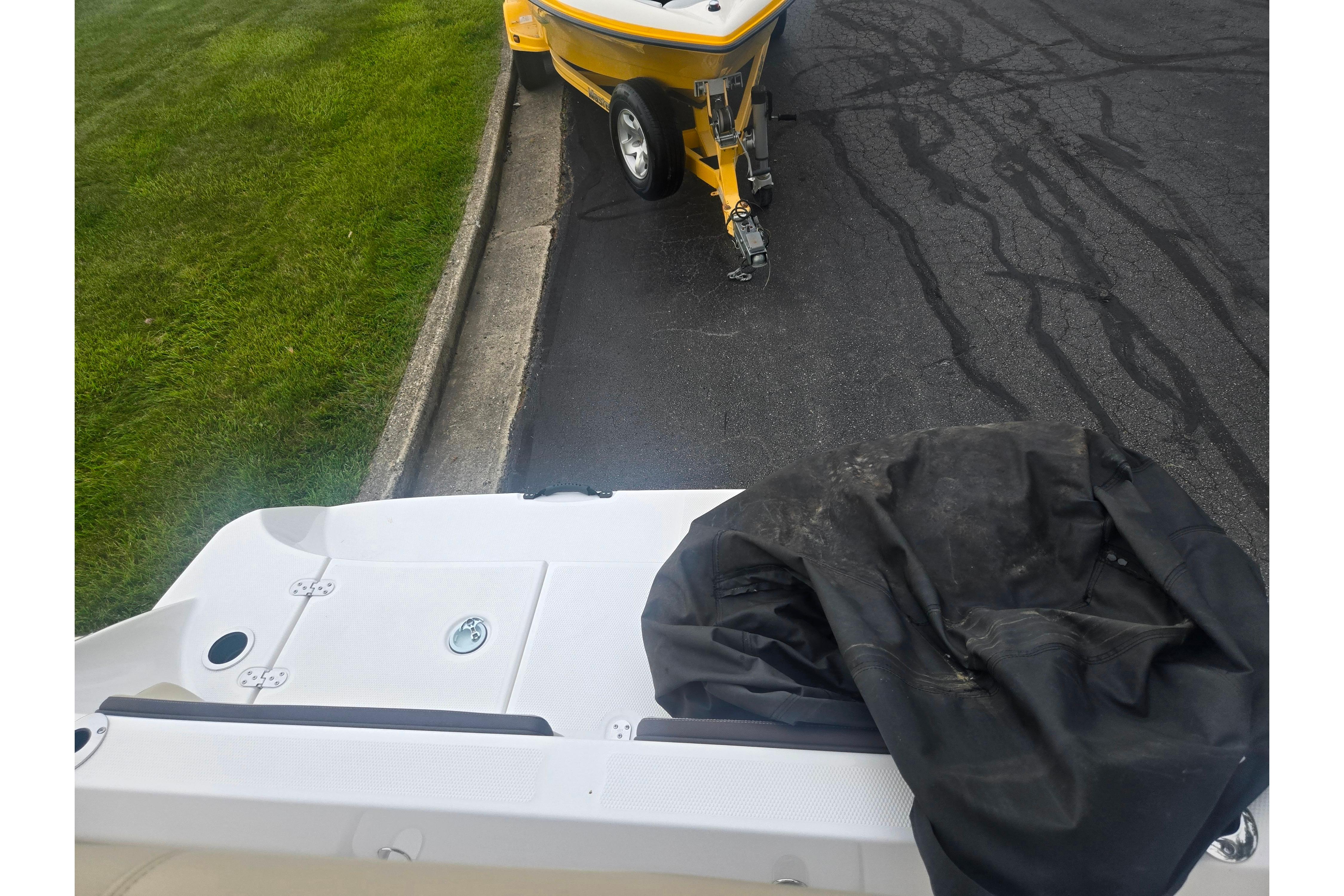 2022 Yamaha Boats 195 FSH Sport on trailer, parked on asphalt near grass.