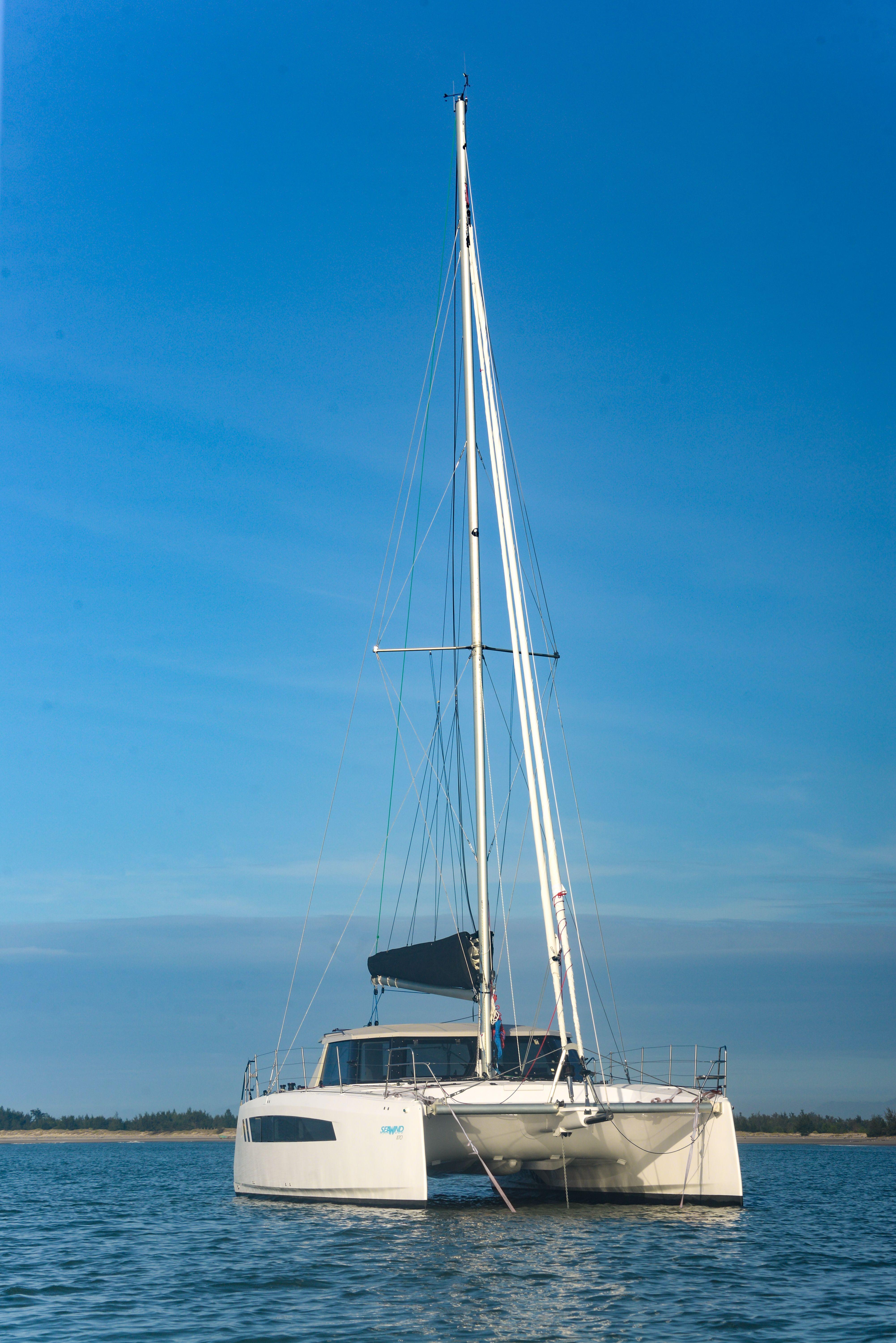 2025 Seawind 1170 catamaran sailing on calm waters under a clear blue sky.