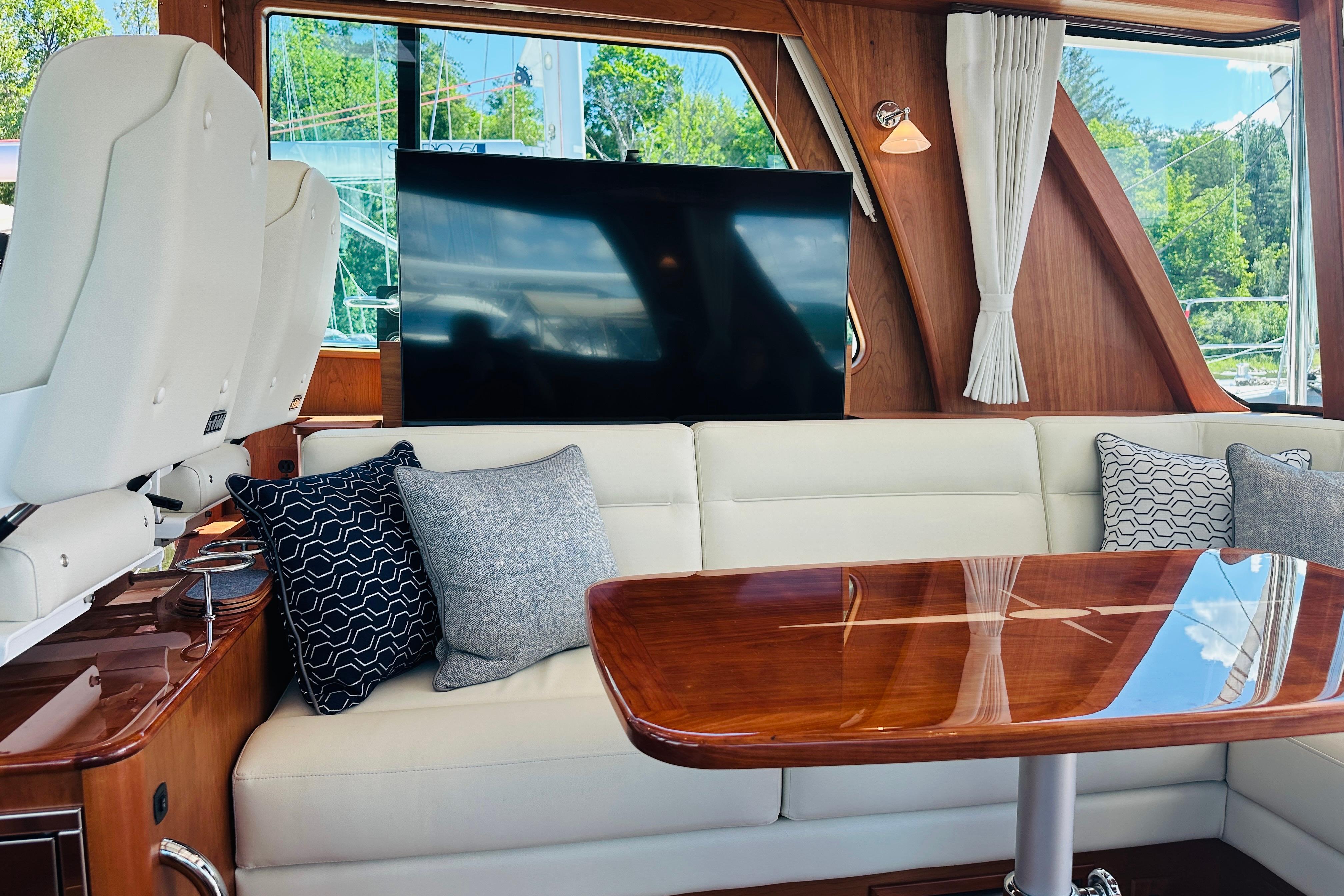 Luxurious interior of 2025 Sabre 48 Salon Express yacht with elegant seating and wooden table.
