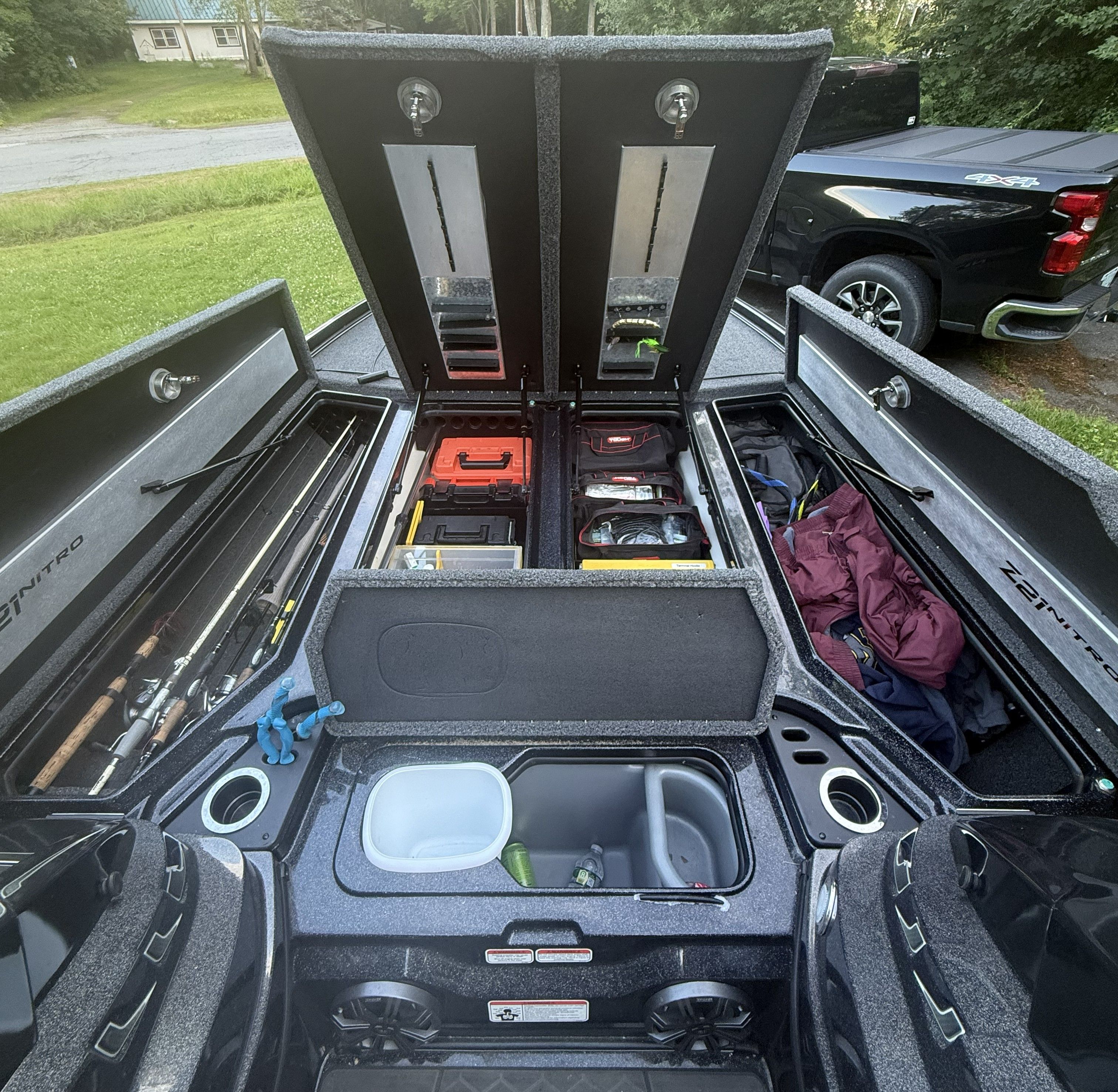 The image shows the open storage compartments of a Nitro Z21 XL Pro boat with fishing gear.