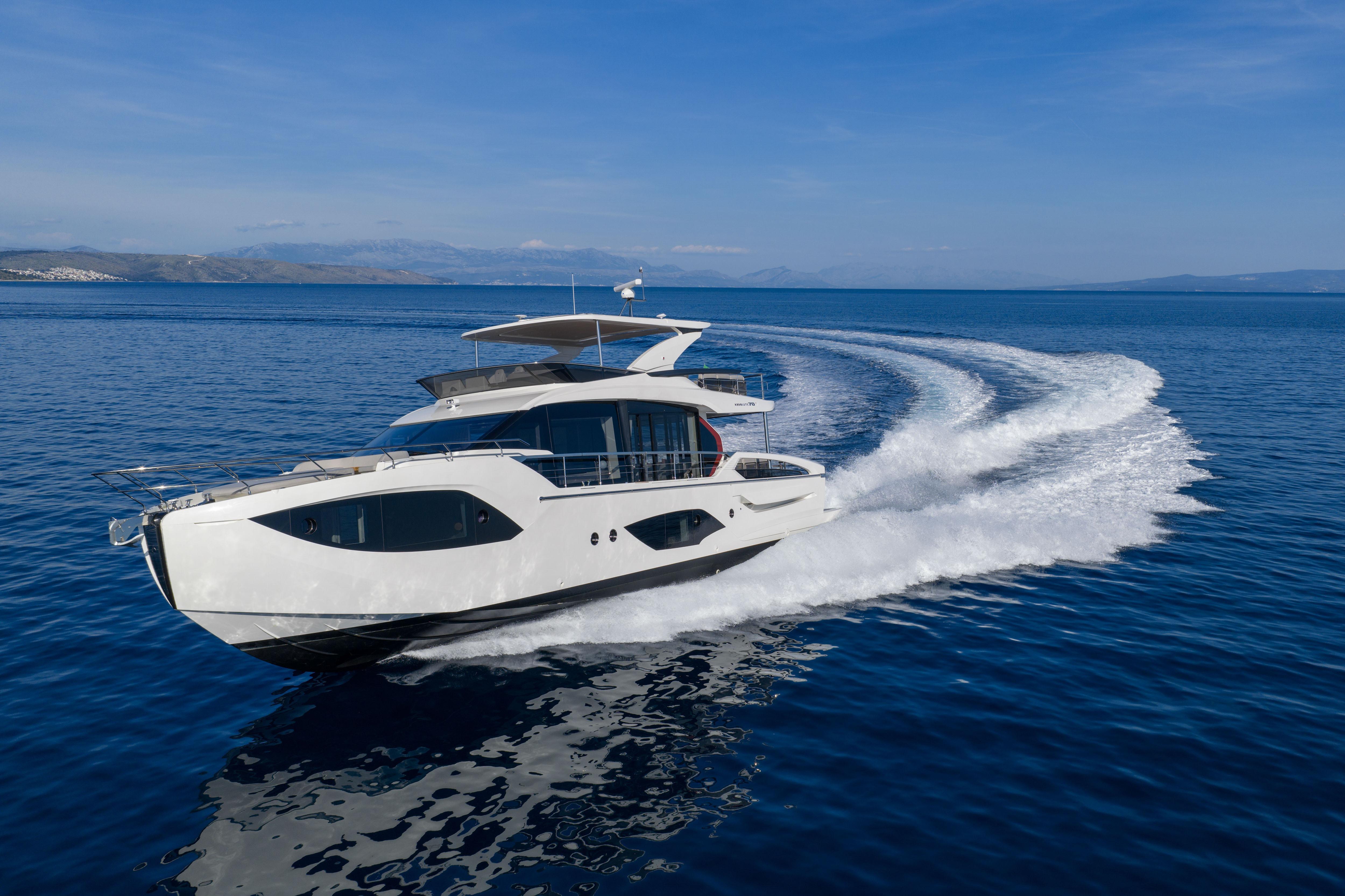 Luxury yacht cruising on calm sea, leaving a white wake trail.