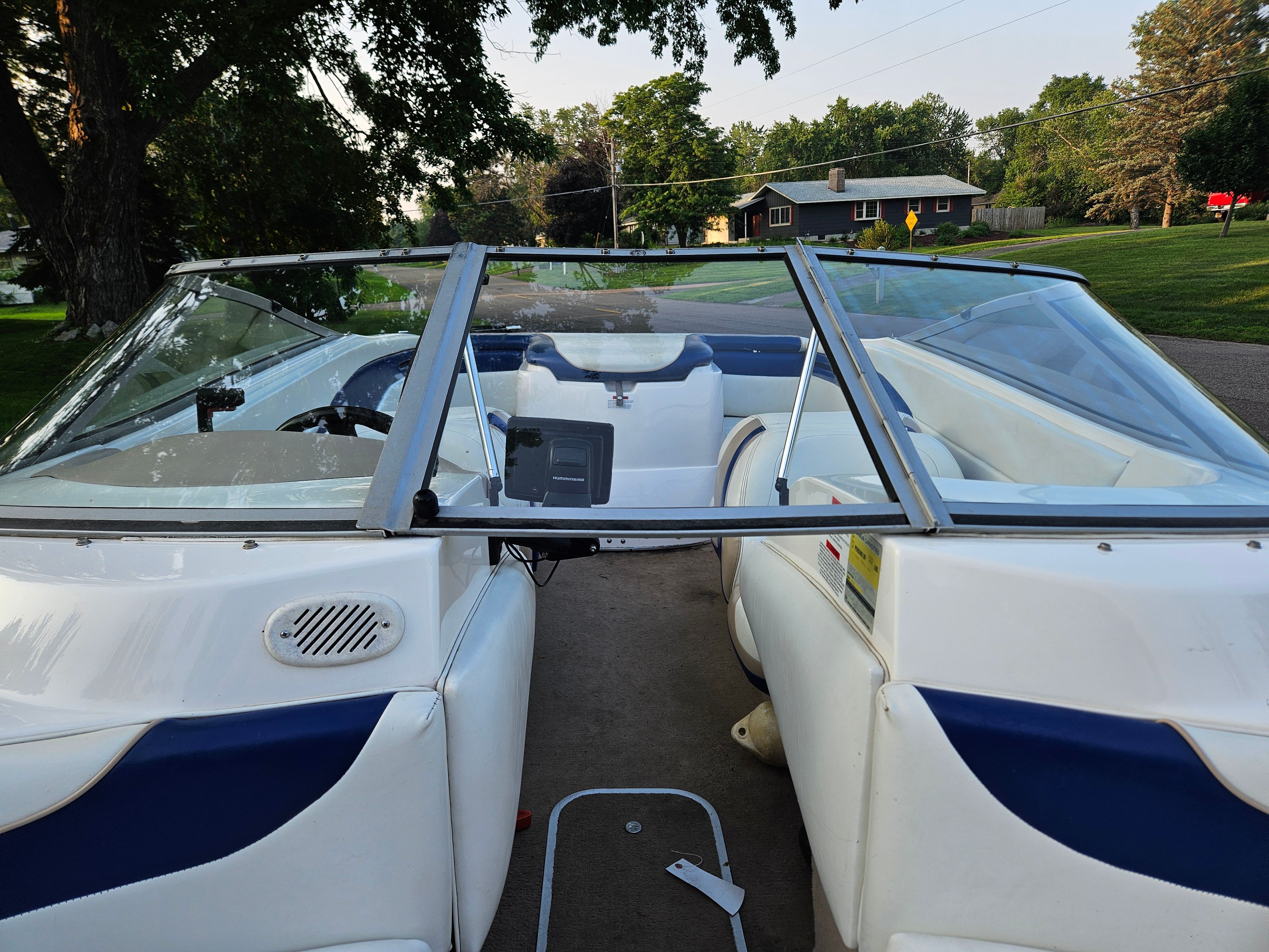 The image shows the cockpit of a 1996 Wellcraft Excel boat with white and blue seating.