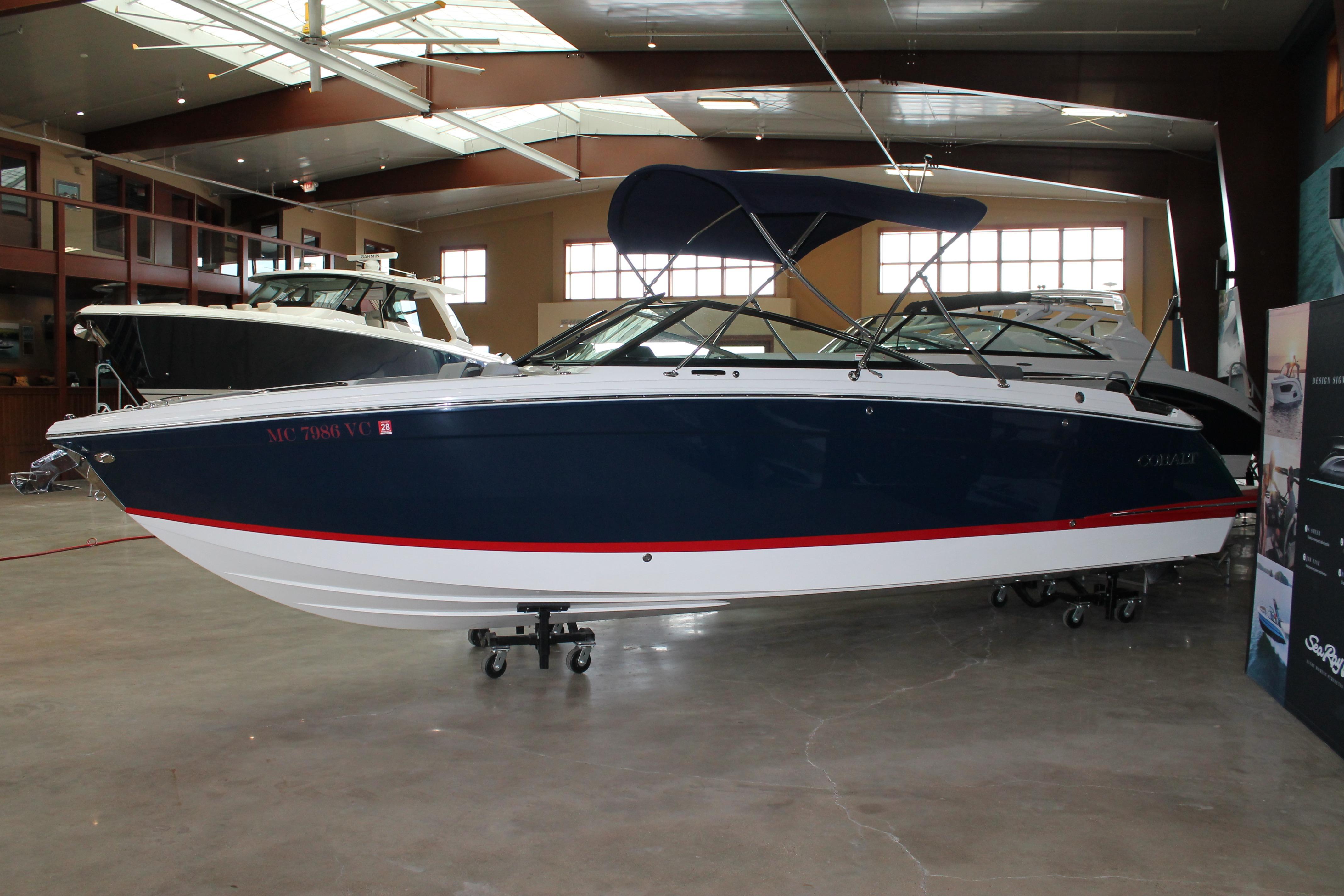 2023 Cobalt R8 boat in showroom, featuring sleek design and navy blue exterior.