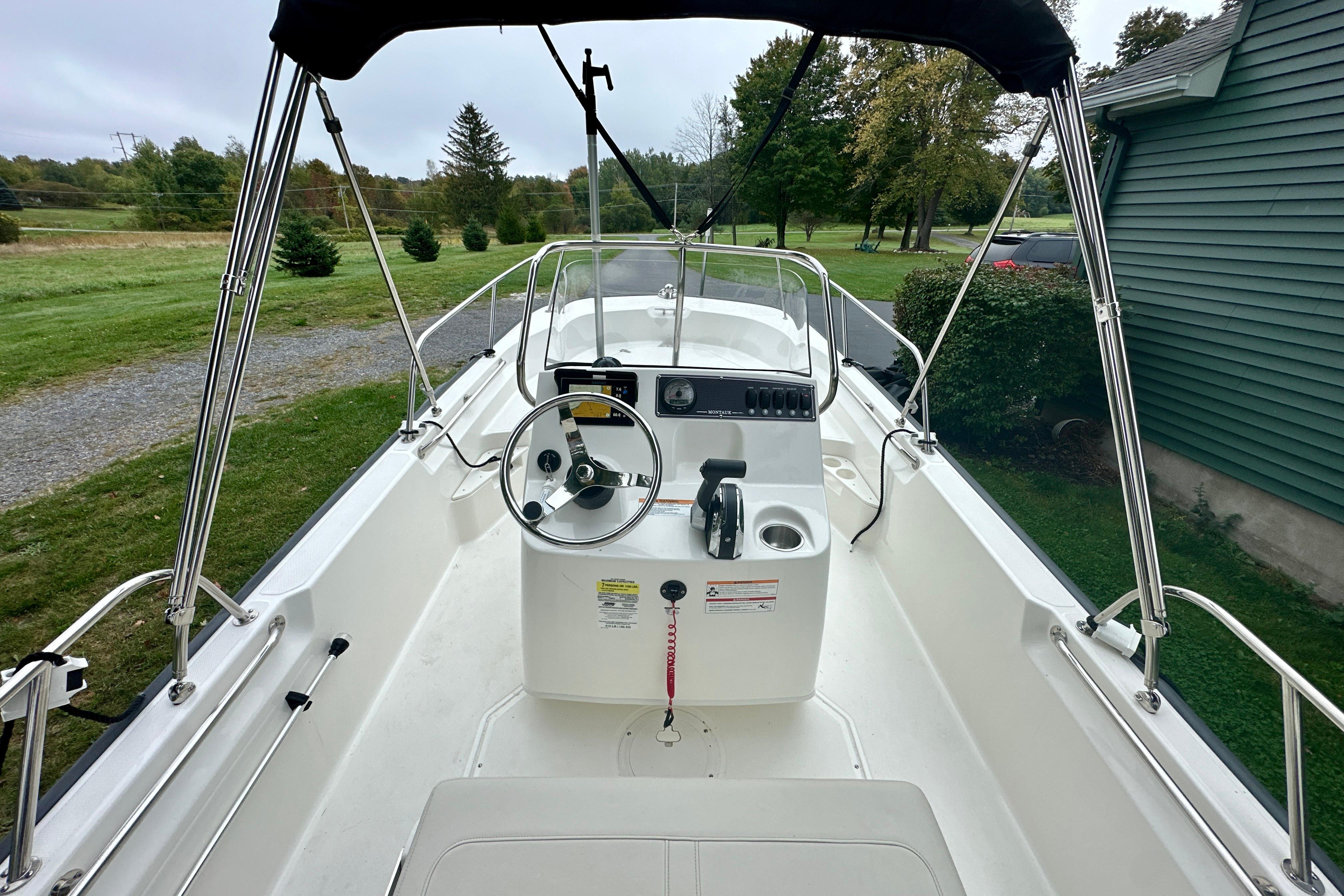 2024 Boston Whaler 170 Montauk boat interior with steering console and canopy.
