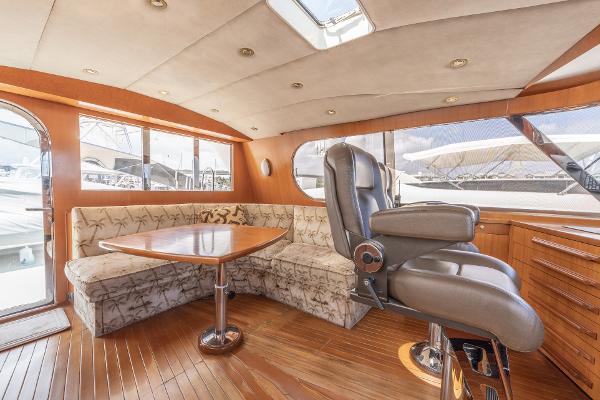 Luxurious interior of a 2001 Grand Harbour 76 yacht with plush seating and wooden finishes.