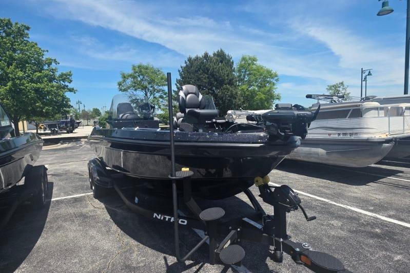 2026 Nitro ZV21 boat in parking lot, sunny day, surrounded by trees and other boats.