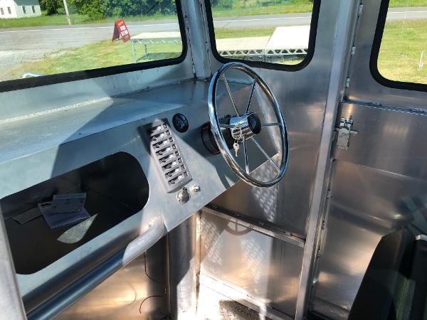 Interior view of a workboat with steering wheel and control console.
