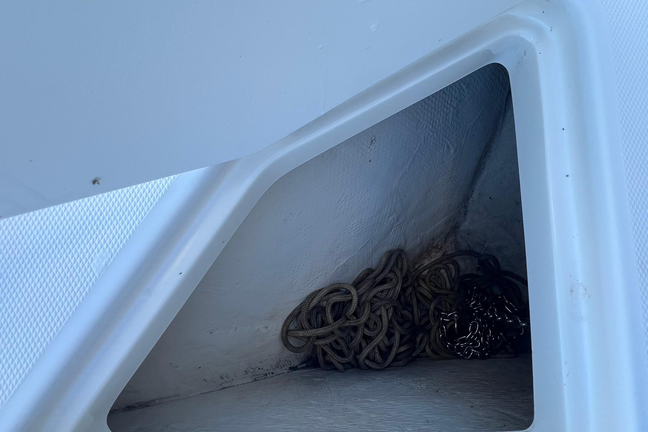 Storage compartment with coiled rope on a 2006 Edgewater 245CC boat.